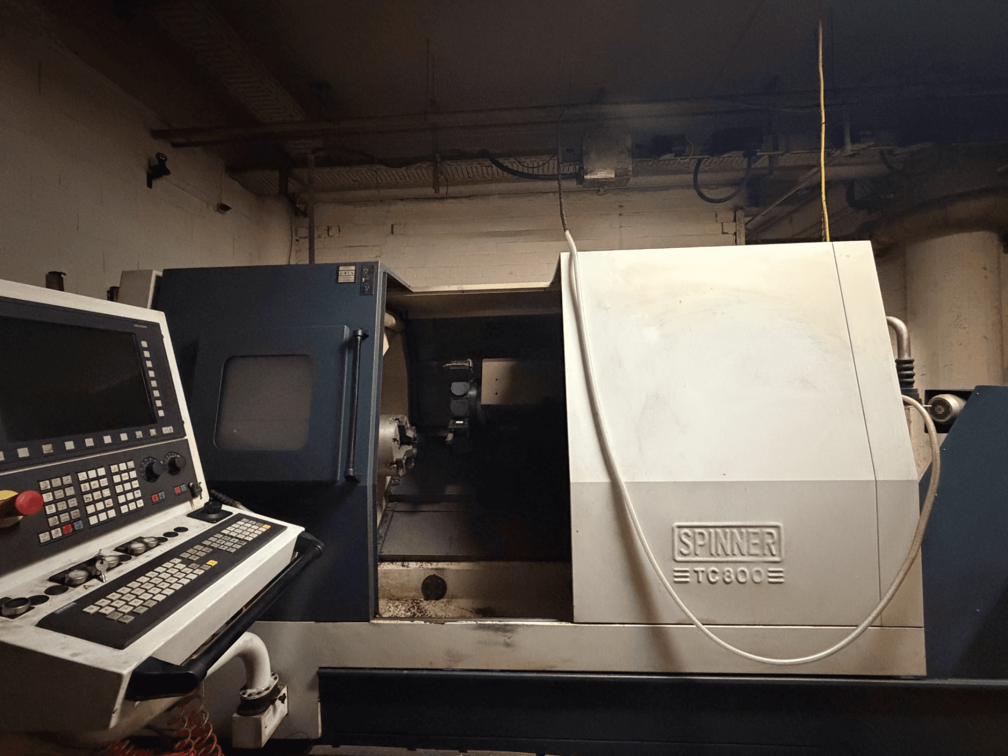 Yatay tornalama makinesi SPINNER TC800, kontrol paneli görünür ve makinenin içi hafifçe açık şekilde önden görünüm.