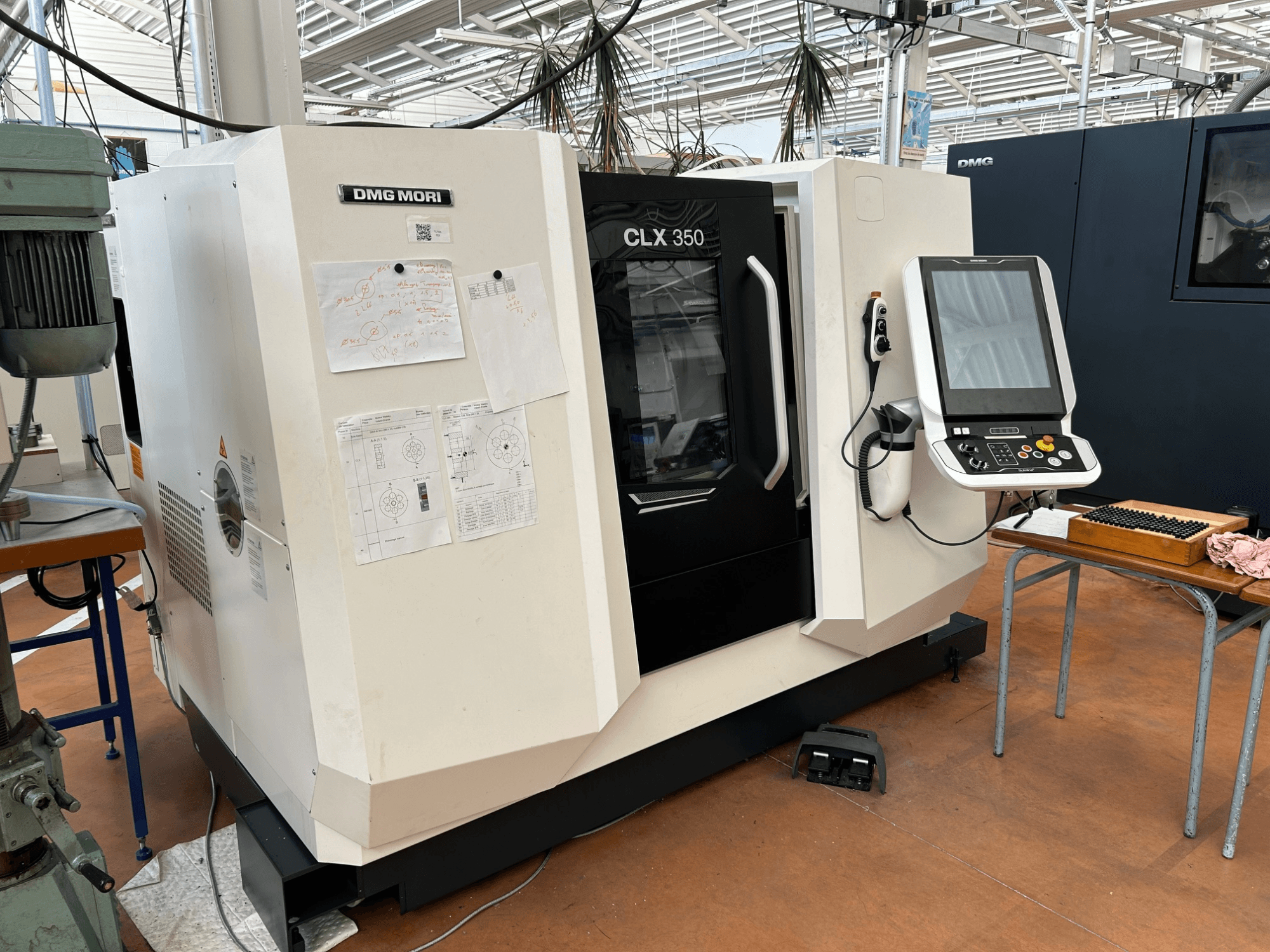 DMG MORI CLX 350 V4 yatay torna tezgahı, kontrol paneli ile birlikte önden görünüm; teknik belgeler ektedir.