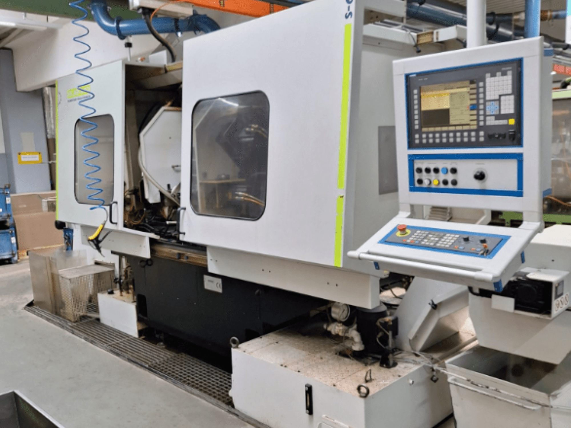 Kontrol panelli, yandan görünümlü, çift hazneli ve görünür boru hattı bağlantılarına sahip endüstriyel freze makinesi.