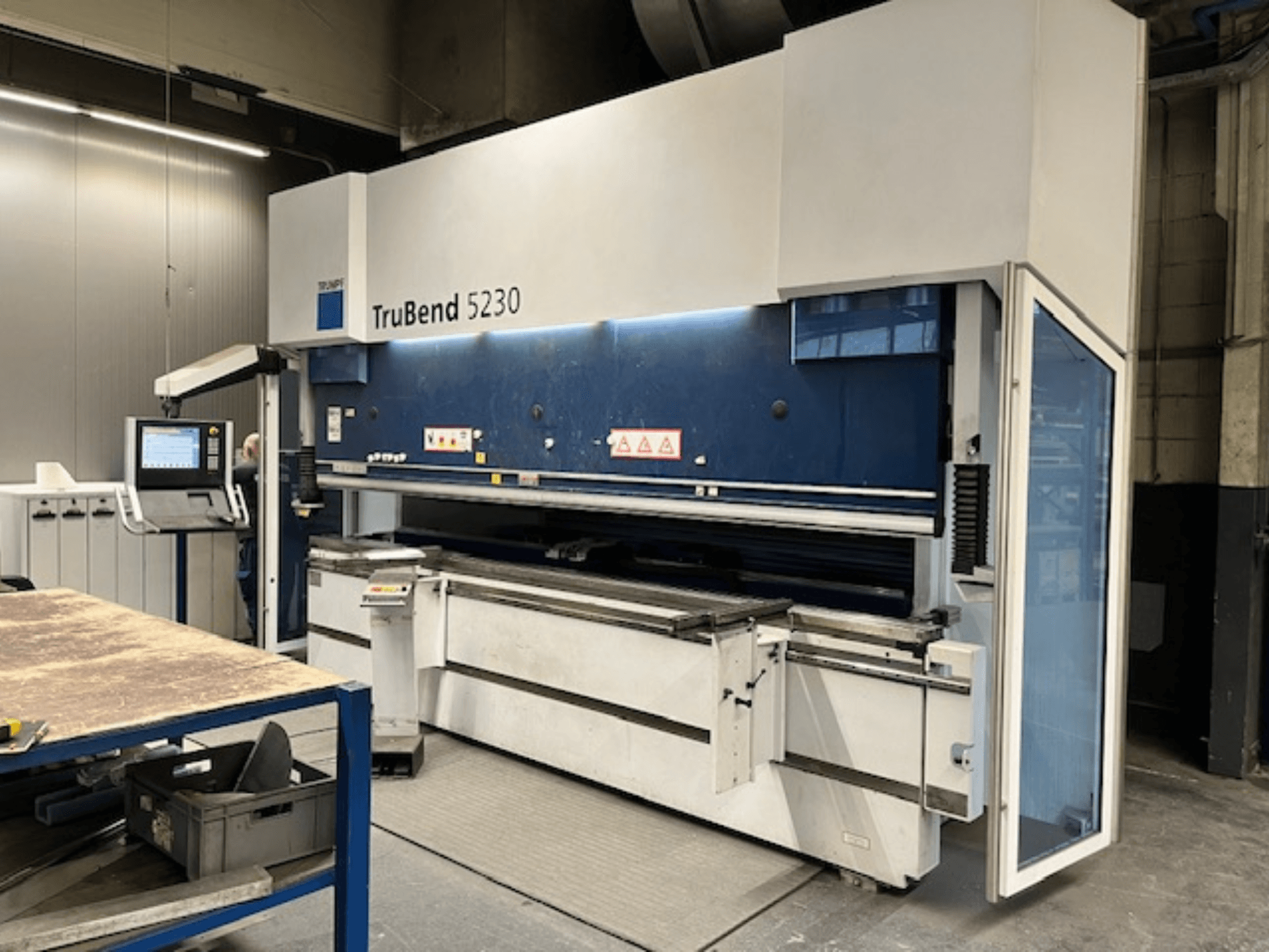 TruBend 5230 bükme makinası, endüstriyel ortamda; kontrol panelini, güvenlik özelliklerini ve çalışma tablasını gösteren önden görünüm.