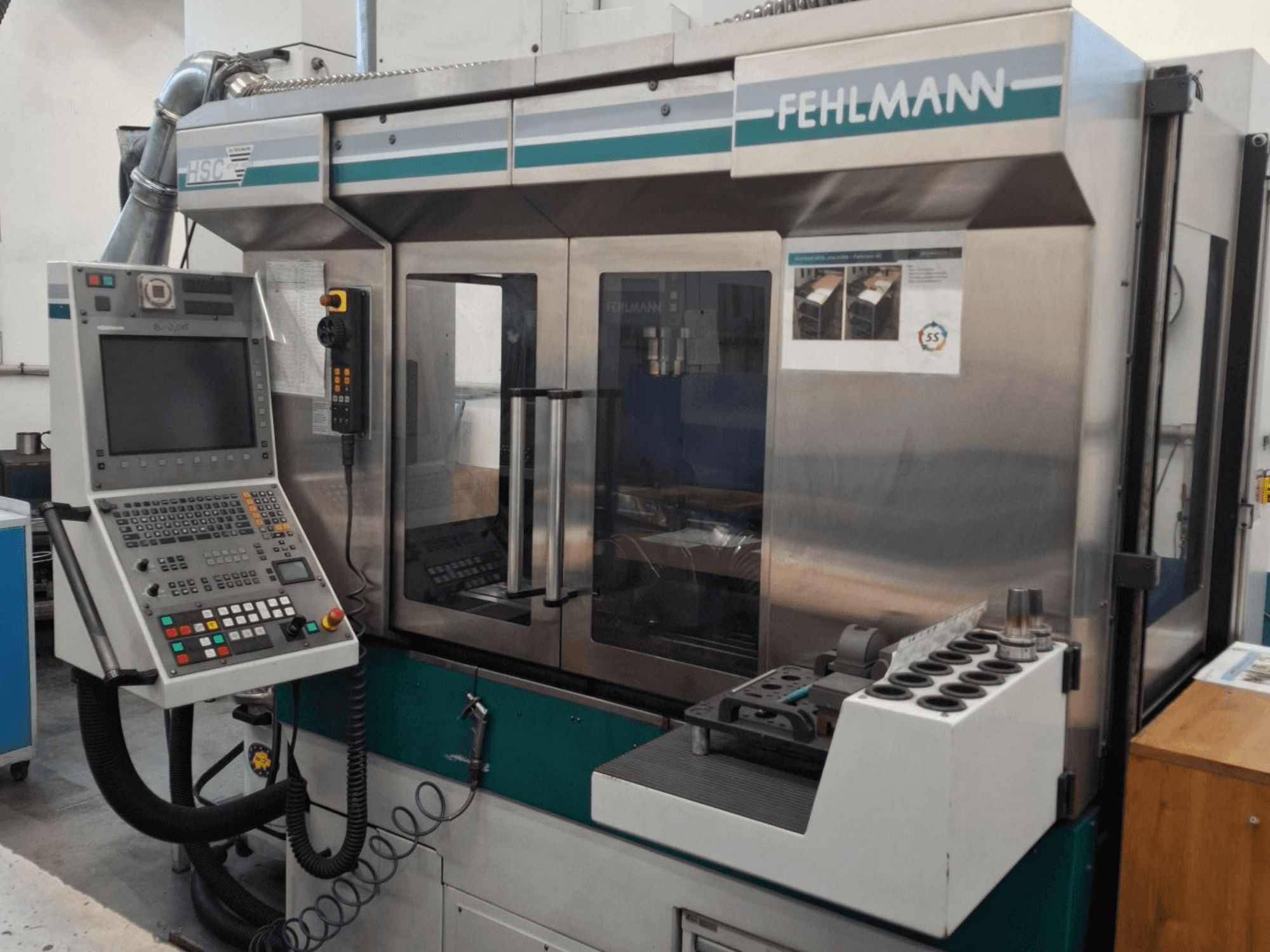Fehlmann HSC 20 CNC makinesi, önden görünüm, kontrol paneli, metal kasa ve çok yuvalı takım tutucu.