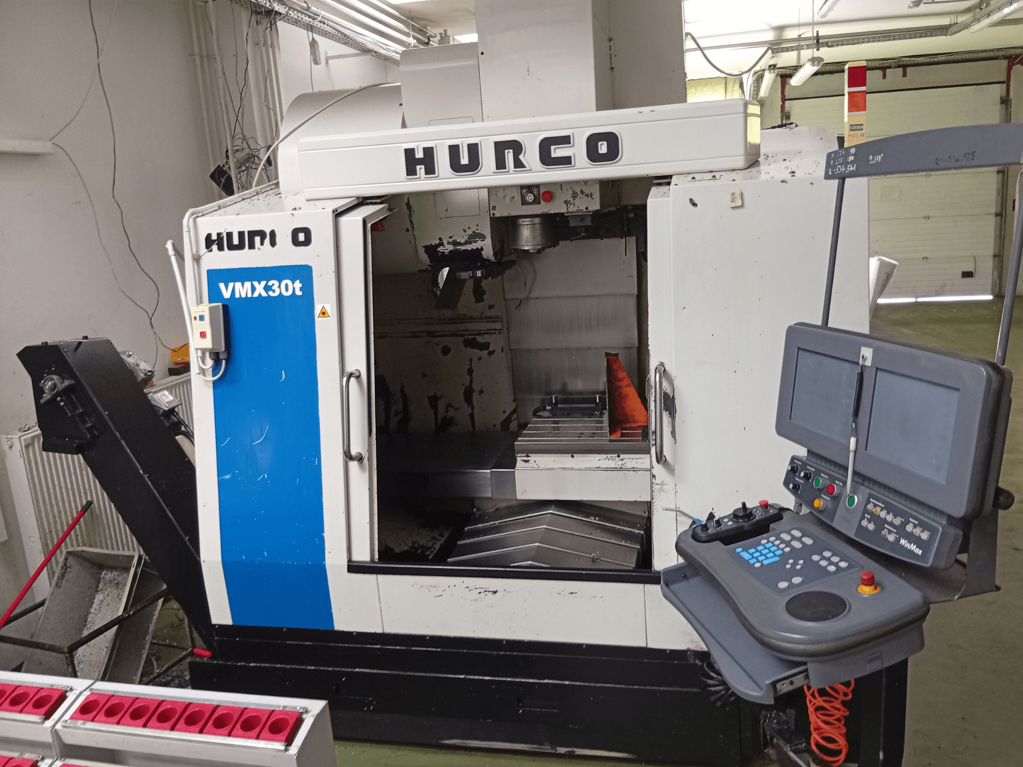 Hurco VMX 30T dikey işleme merkezi, önden görünüm; kontrol paneli ve iş masasının görülebildiği iş mili bölümü.