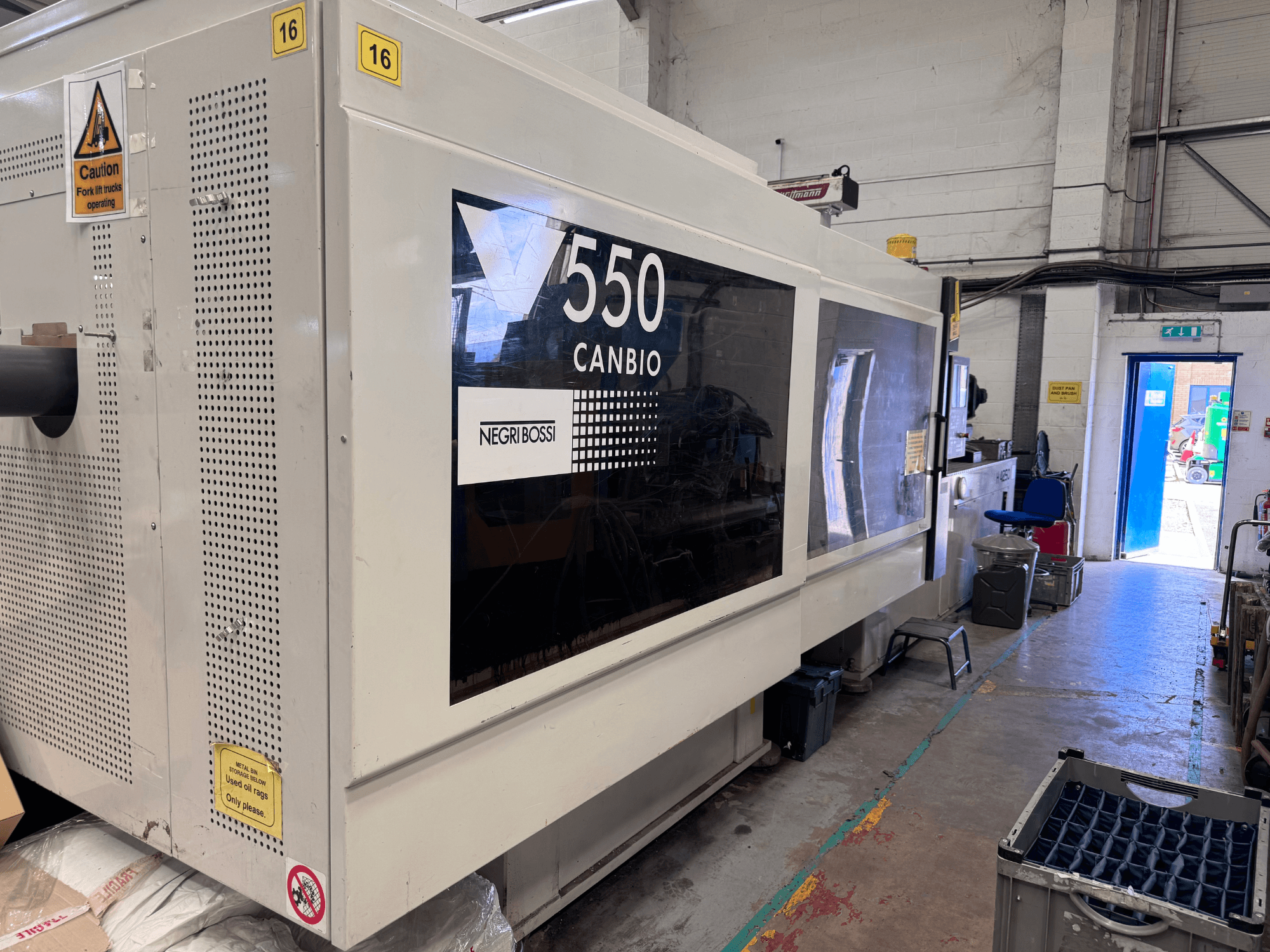 Negri Bossi 5500H-4250 hidrolik enjeksiyon kalıplama makinesi; kontrol paneli ve uyarı işaretlerini gösteren önden görünüm.