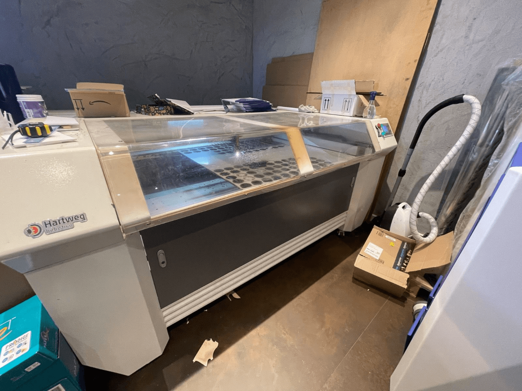 CO2 lazer kesim makinesi Bodor CL-1610XUF yan görünümde, malzeme yuvaları ve kontrol paneli ile çalışma alanını gösterir.