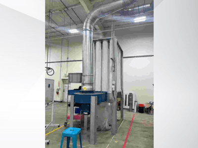 Geniş bir depoda yer alan, parlak metal kanallı ve mavi tabanlı büyük endüstriyel havalandırma sistemi, önden görünüm.