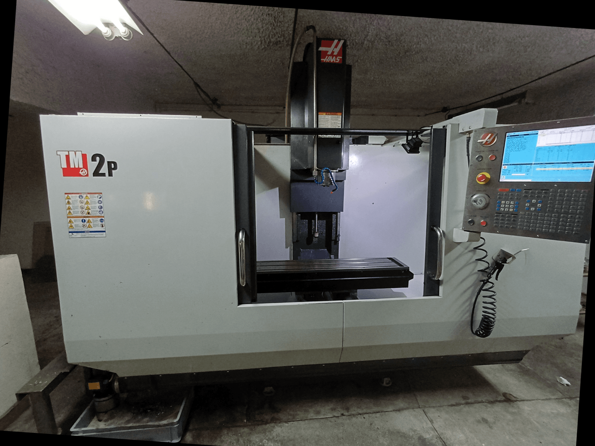 HAAS TM-2P Dikey İşleme Merkezi, önden görünüm, kontrol paneli, iş mili kafası ve makine yatağını gösterir.