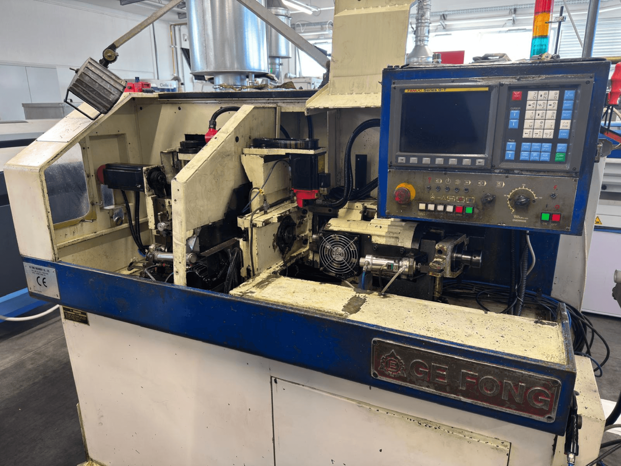 GE FONG endüstriyel makinenin önden görünümü, iç bileşenleri, kontrol panelini ve operasyonel parçaları gösterir.