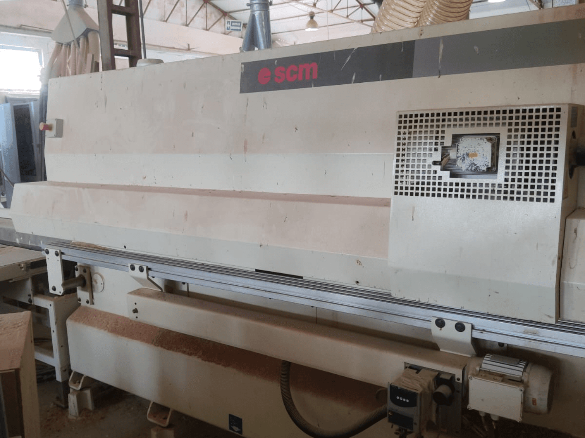 SCM Windor60 CNC Ahşap İşleme Merkezi, önden görünüm. Makinenin kumanda paneli ve toz toplama sistemi görülüyor; altında ahşap talaşları bulunuyor.