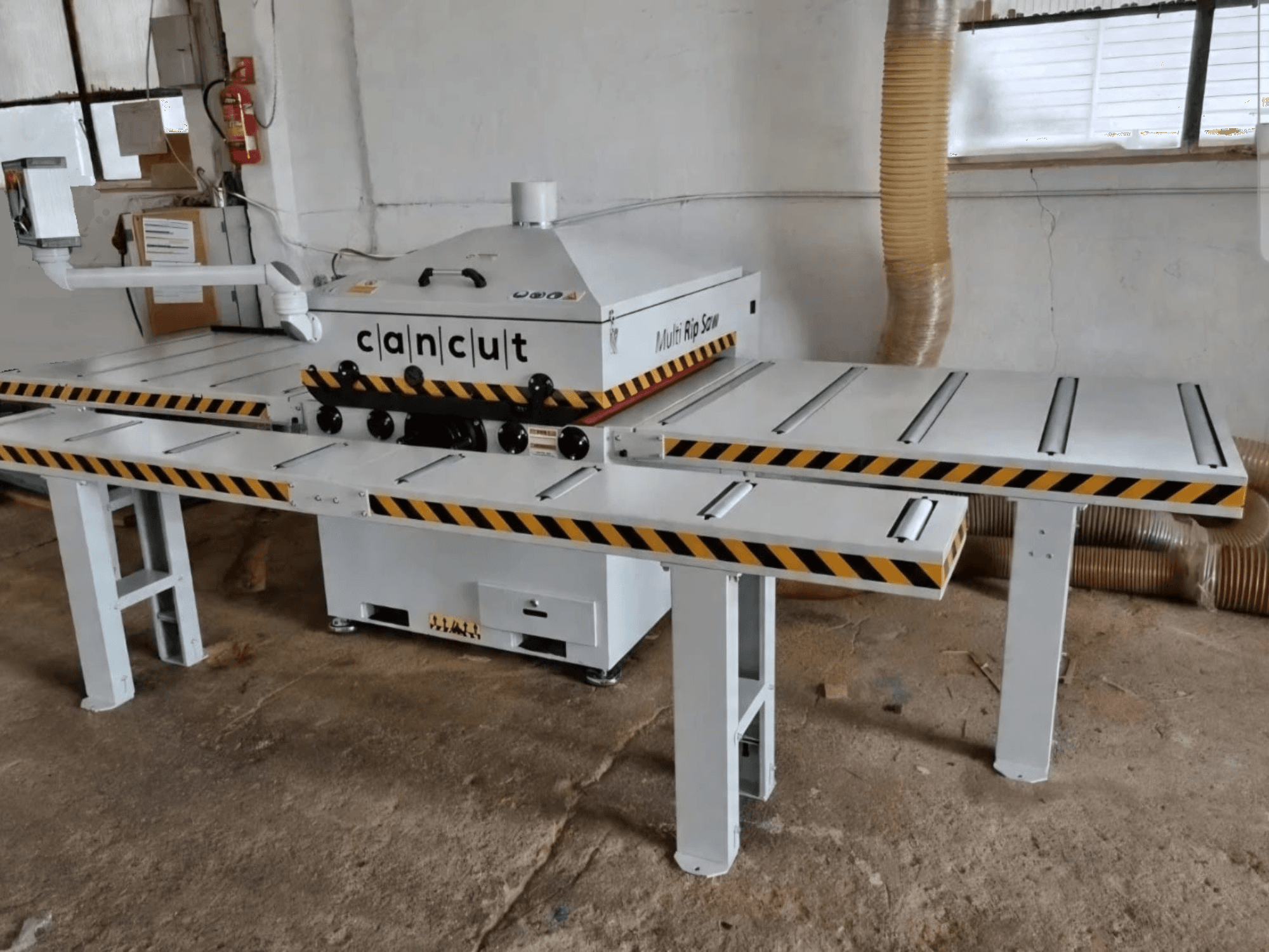Çift emniyet şeritli masalara sahip CAN CUT MC 930 dairesel ahşap testere, kapalı bir atölye ortamında önden bakıldığında.