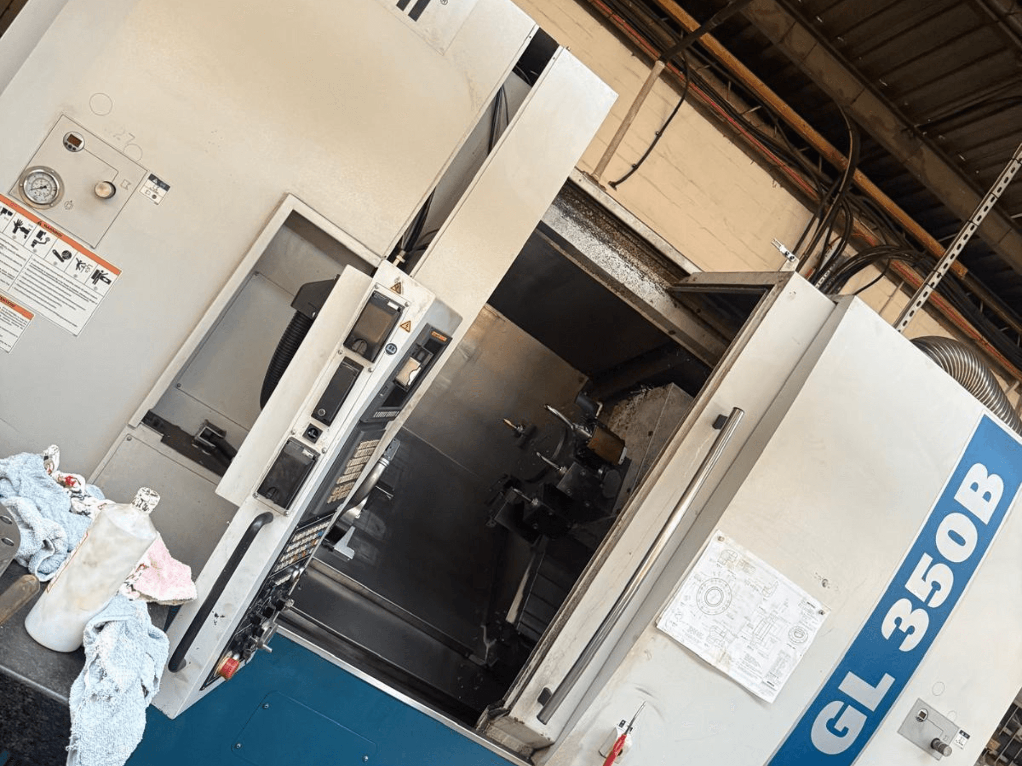 Yatay tornalama makinesi Romi GL 350B, önden görünüm, kontrol paneli ve iç kısmı gösteren açık kapı.