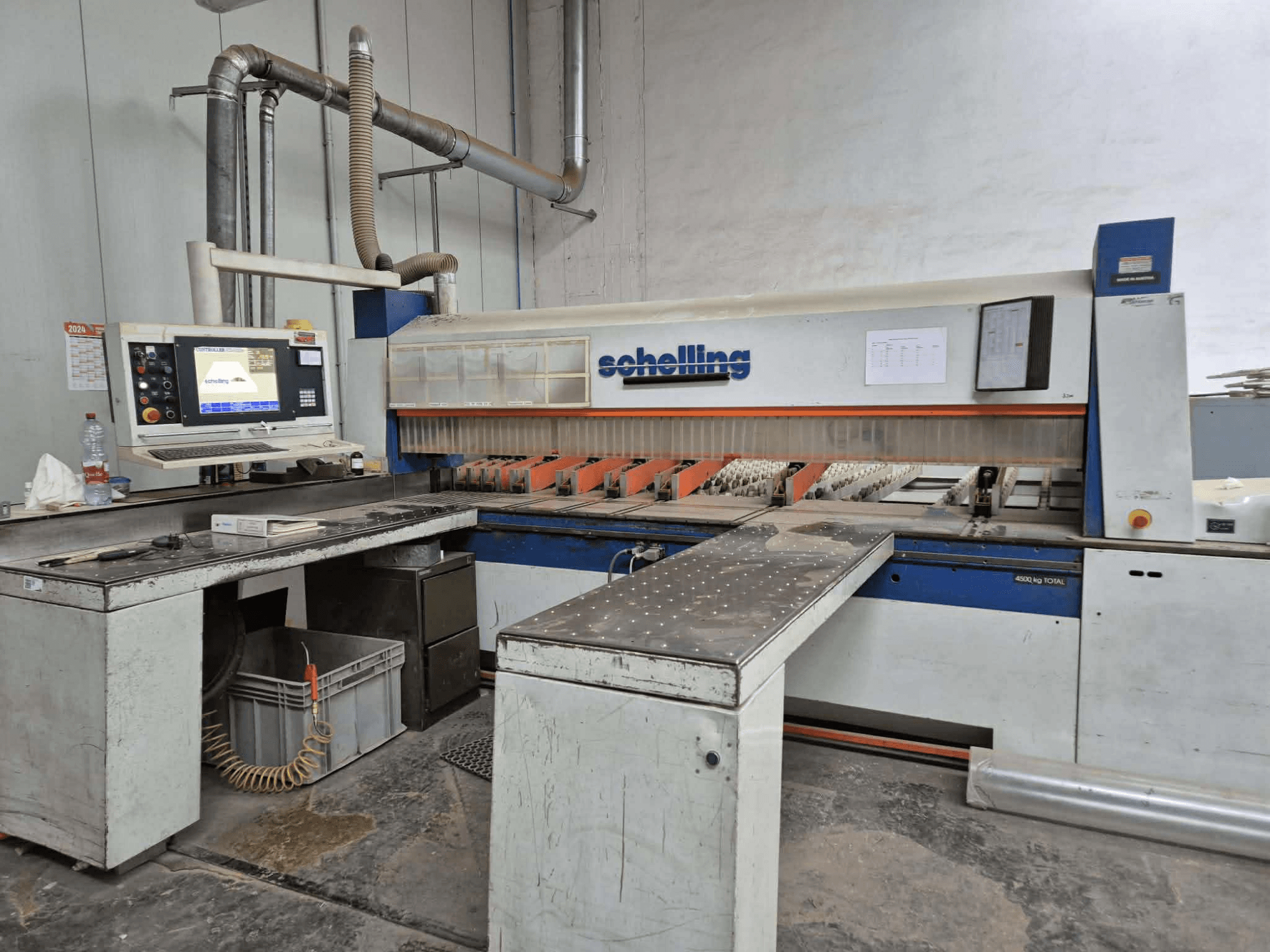 Schaublin kesim makinesinin yandan görünümü, bir bilgisayar arayüzü, keskin bıçaklar ve sağlam bir metal çalışma yüzeyi içerir.