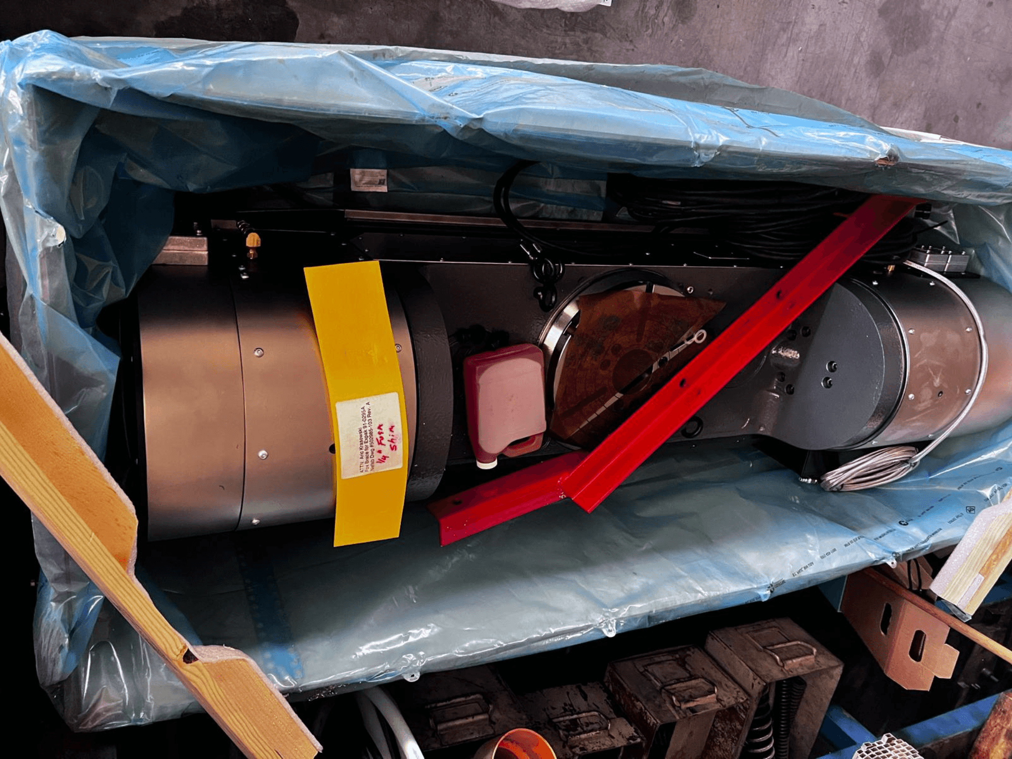 Ambalajda kısmen görülebilen motor cihazı, gümüş renkli bir dış yüzeye, renkli göstergelere ve kırmızı destek desteğine sahiptir.