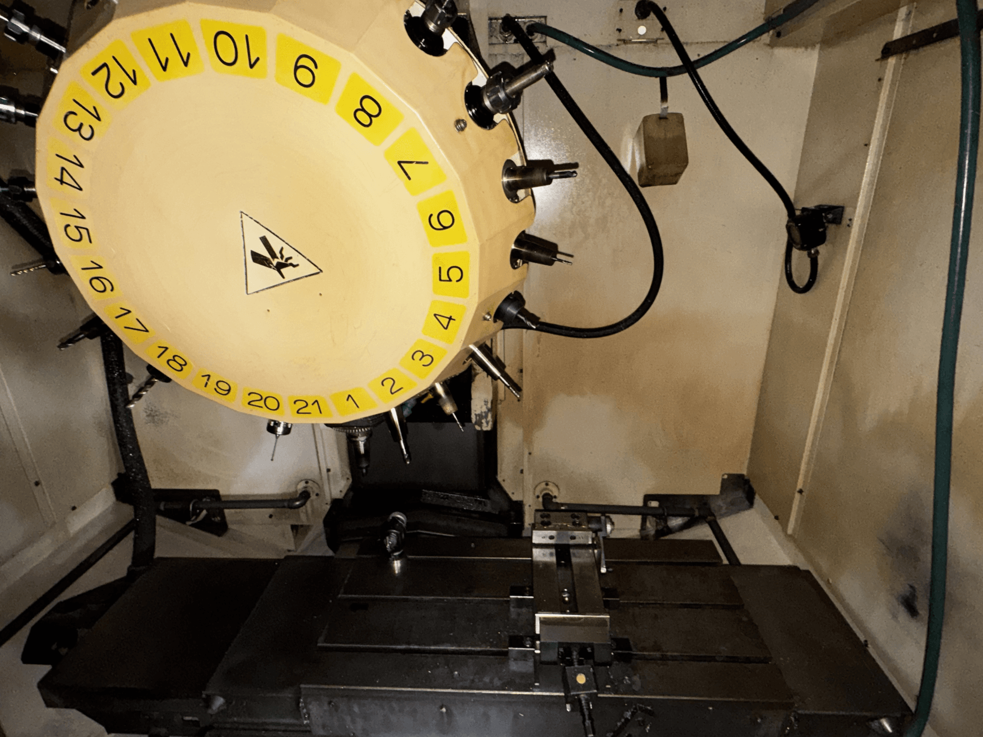 FANUC Robodrill alpha-T21iFL dikey işleme merkezi iç görünümü, takım karuseli ve işleme tablası görünür.