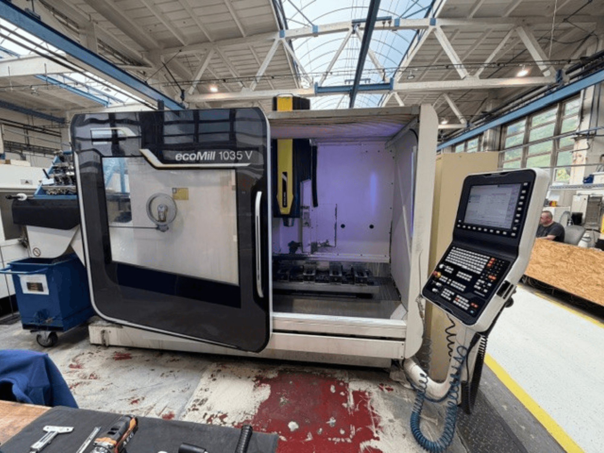 Kapısı açık DMG MORI ecoMill 1035V dikey işleme merkezinin önden görünümü; iç kısımdaki kontrol paneli ve çalışma alanı görülebilmektedir.