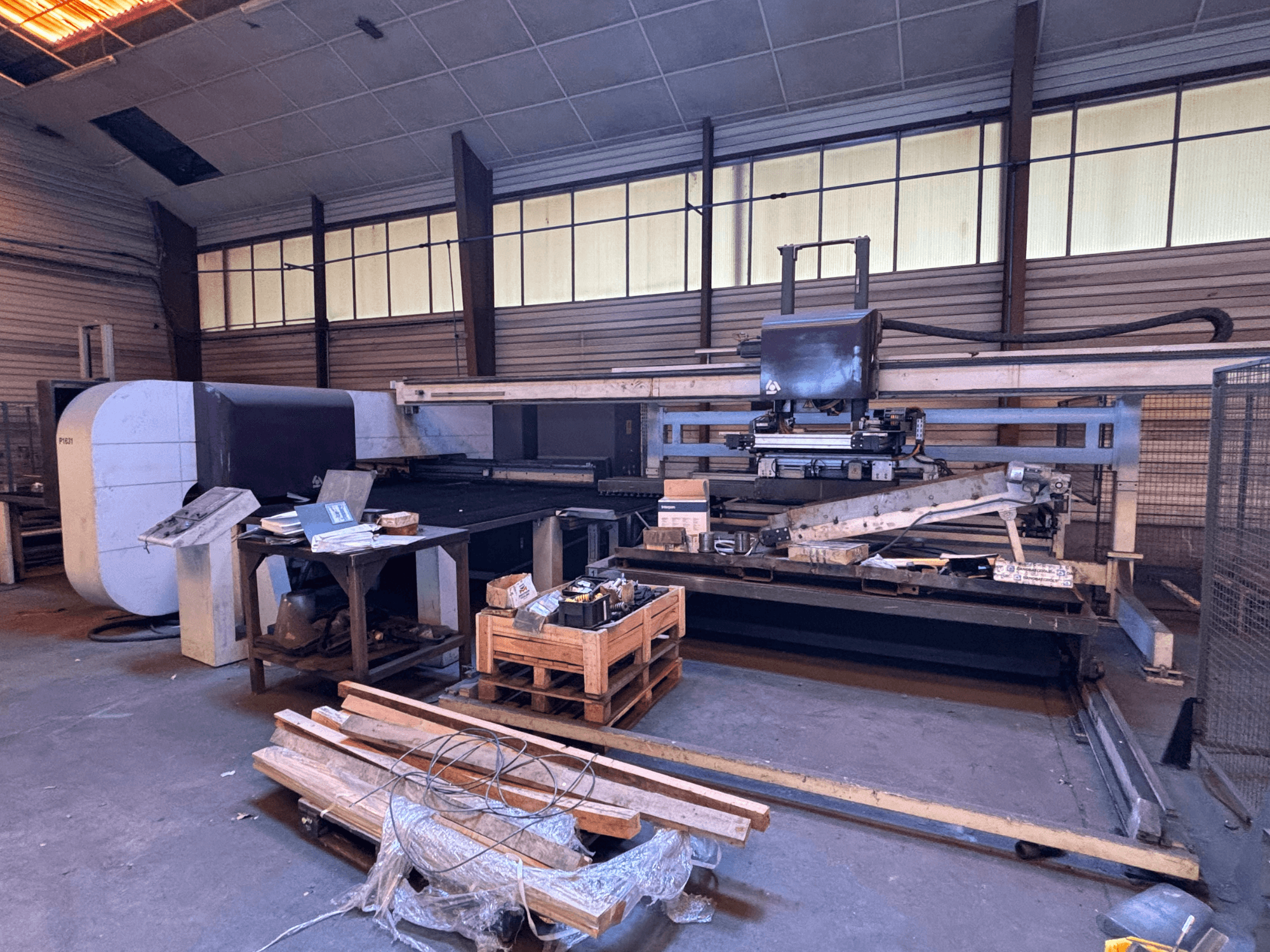 CNC delme makinesi DANOBAT P1631 bir atölyede, önden görünüm, dağınık bir zemin üzerinde malzemeler ve aletlerle çevrili.