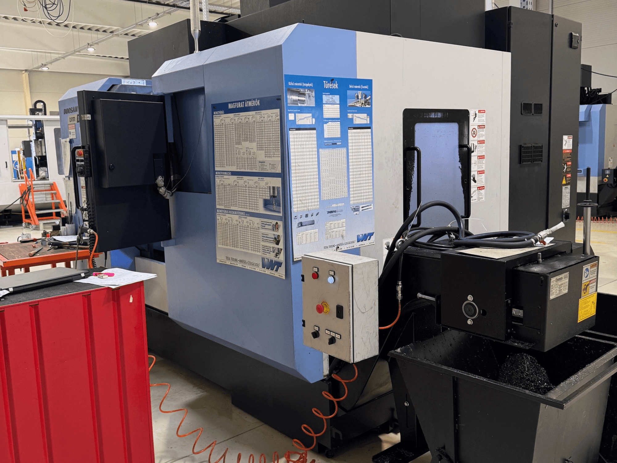DOOSAN DNM350/5AX freze-torna merkezi; kontrol paneli ve soğutma sıvısı tankını gösteren yan görünüm, çalışma detayları görülebilir.