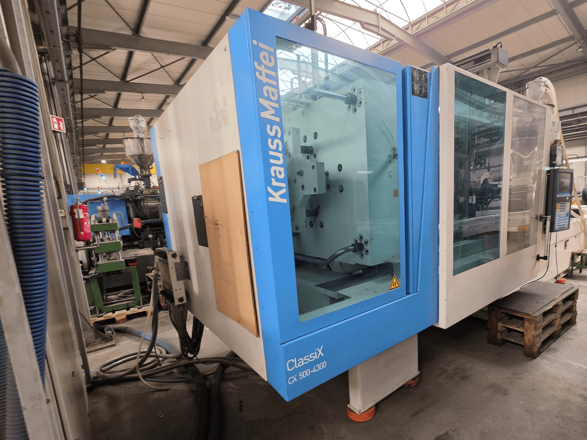 Krauss Maffei 500-4300 CX hidrolik enjeksiyon kalıplama makinesi, yandan görünüm, kontrol paneli ve çalışma bileşenleri.