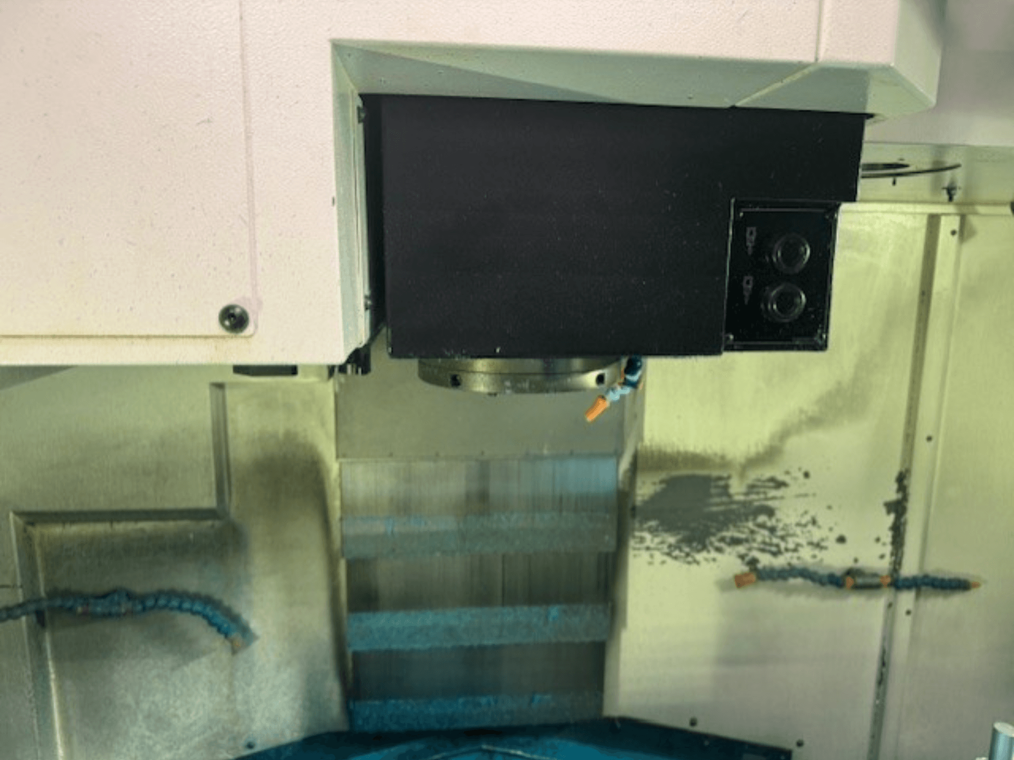 Marka detaylarını, düğmeleri ve çalışma yüzeyini sergileyen bir CNC freze makinesi kontrol panelinin ve takım tutucusunun yakın çekimi.