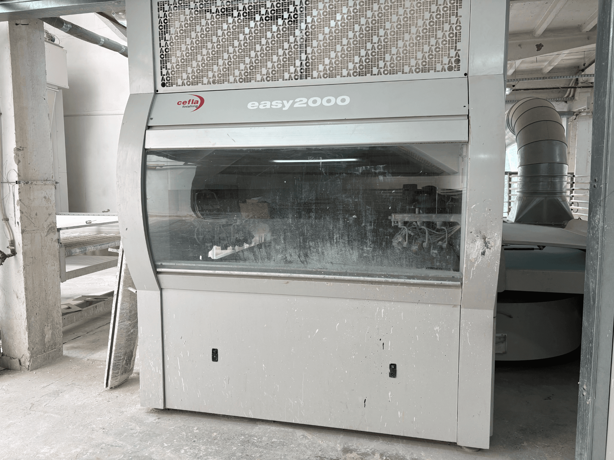 Cefla EASY 2000 D makinesinin önden görünümü; geniş şeffaf paneli, tozlu yüzeyi ve görünür iç bileşenleri ile dikkat çekiyor.