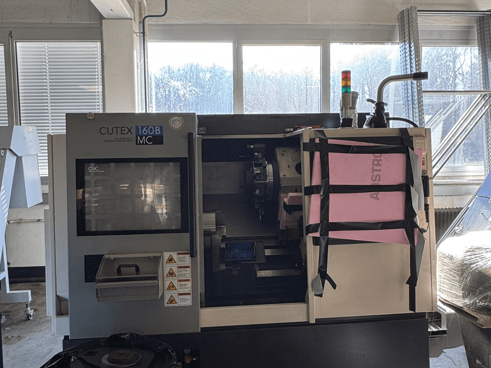 HWACHEON CUTEX 160 B VDI yatay torna tezgahının, kontrol paneli ve soğutma sıvısı tankı ile birlikte, bir güvenlik ışığına sahip olan önden görünümü.