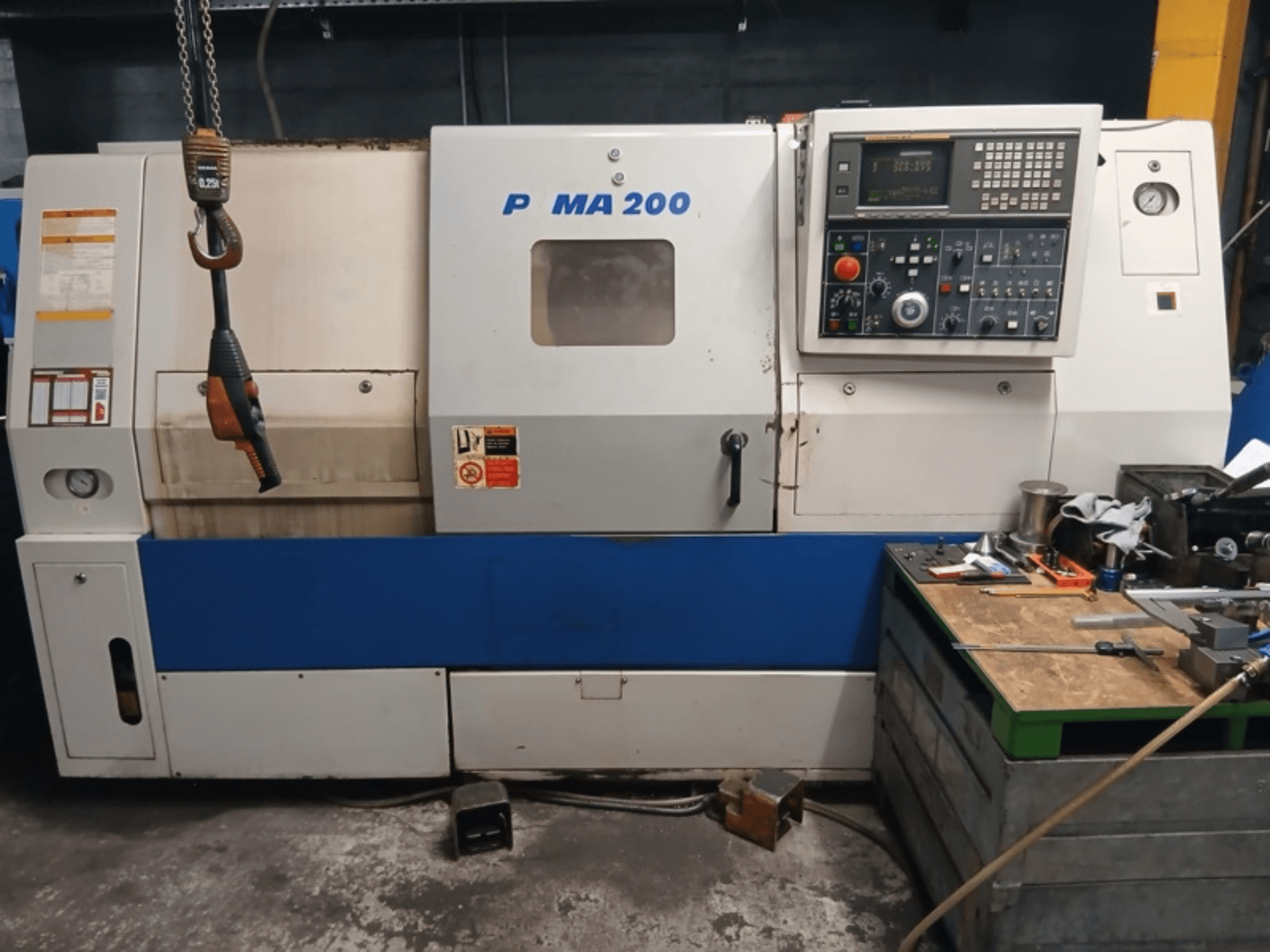 DAEWOO EcoTurn 200 yatay torna tezgahının önden görünümü; kontrol paneli ve güvenlik etiketleri görülmektedir.