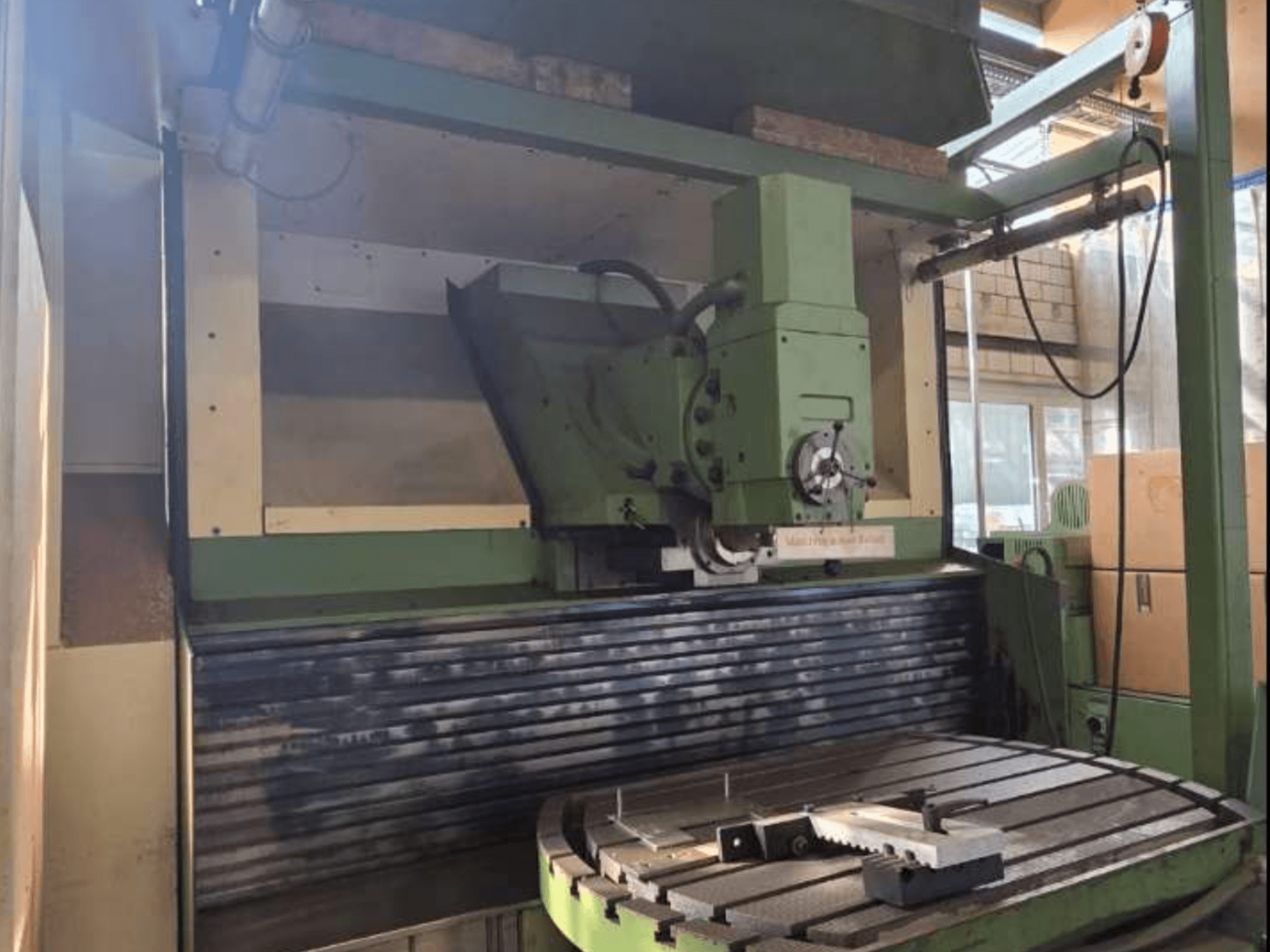 MAHO MH1000 C Üniversal İşleme Merkezi önden görünümde, yeşil yapıyı, iş milini ve döner tablayı bir iş parçası ile birlikte sergiliyor.