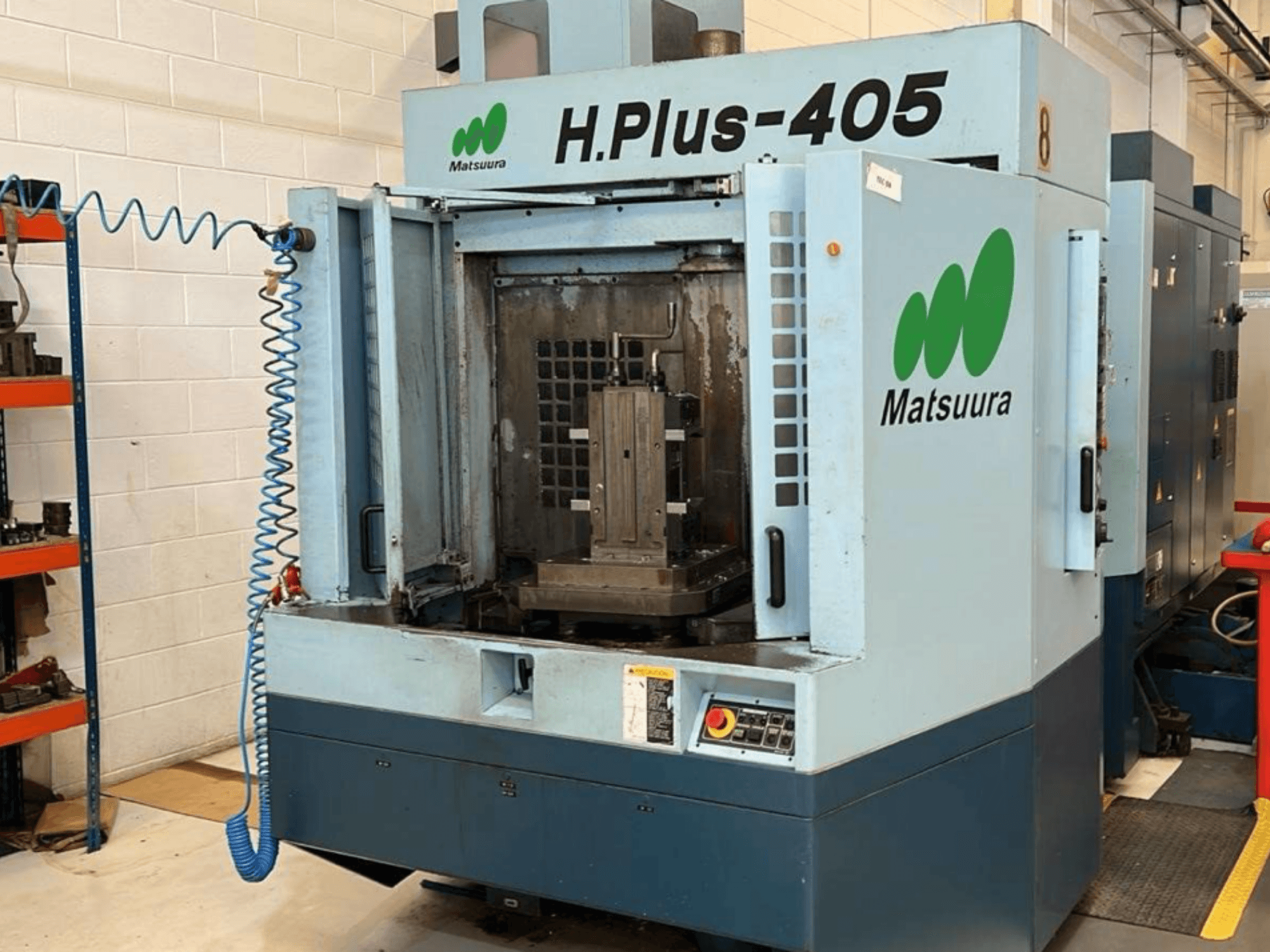 Kapısı açık bir Matsuura H.Plus 405 yatay işleme merkezinin önden görünümü; çalışma alanı ve kontrol paneli görülebilmektedir.