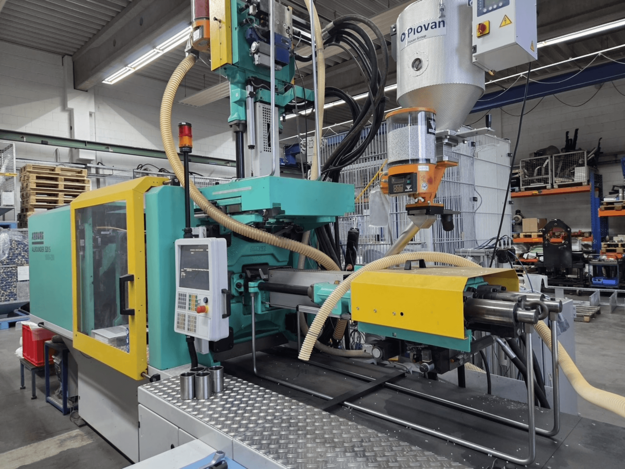 Hidrolik enjeksiyon kalıplama makinesi Arburg Allrounder 520 S 1600-290, önden görünüm, kontrol paneli ve malzeme besleyici görünür.