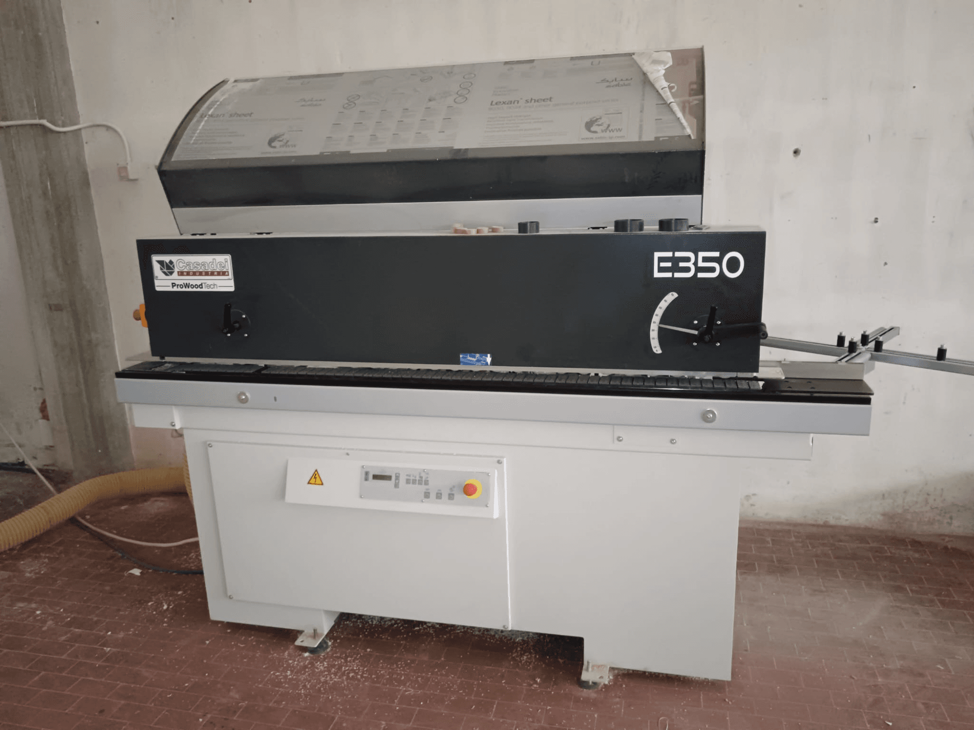 Cesaroli ProWoodtech E350, beyaz bir taban üzerine monte edilmiş, kontrol panelli ve toz biriktirmeli bir ahşap işleme makinesinin yandan görünümü.