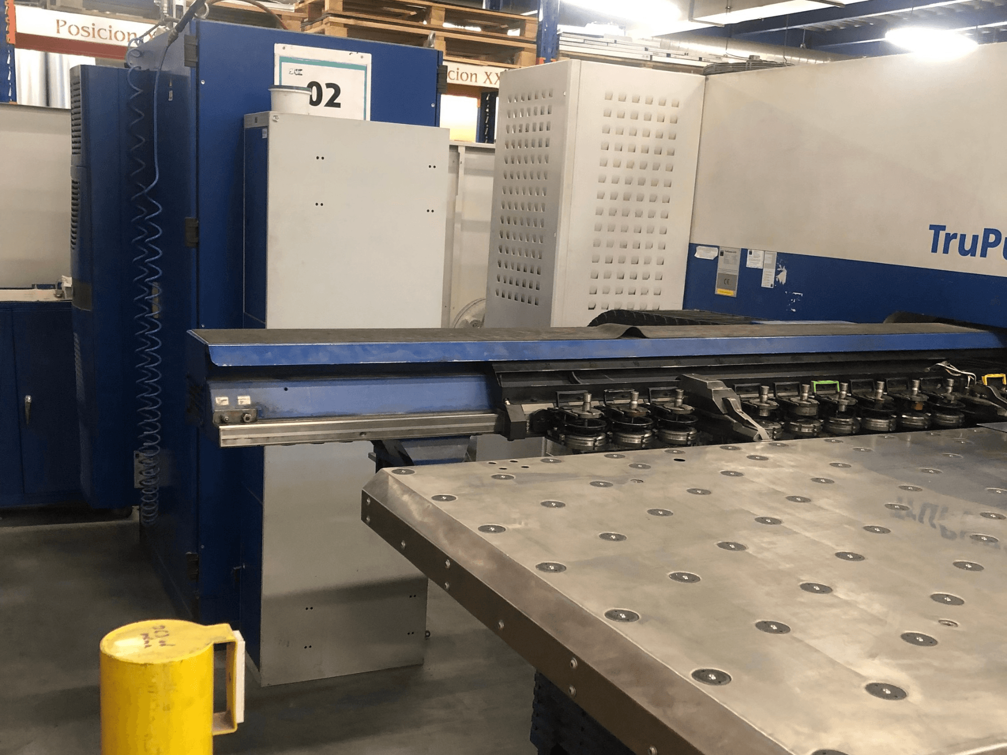 TRUMPF TruPunch 5000 CNC delme makinesi; alet kulesi ve kontrol panelini gösteren önden görünüm, yanında metal bir çalışma masası bulunmaktadır.