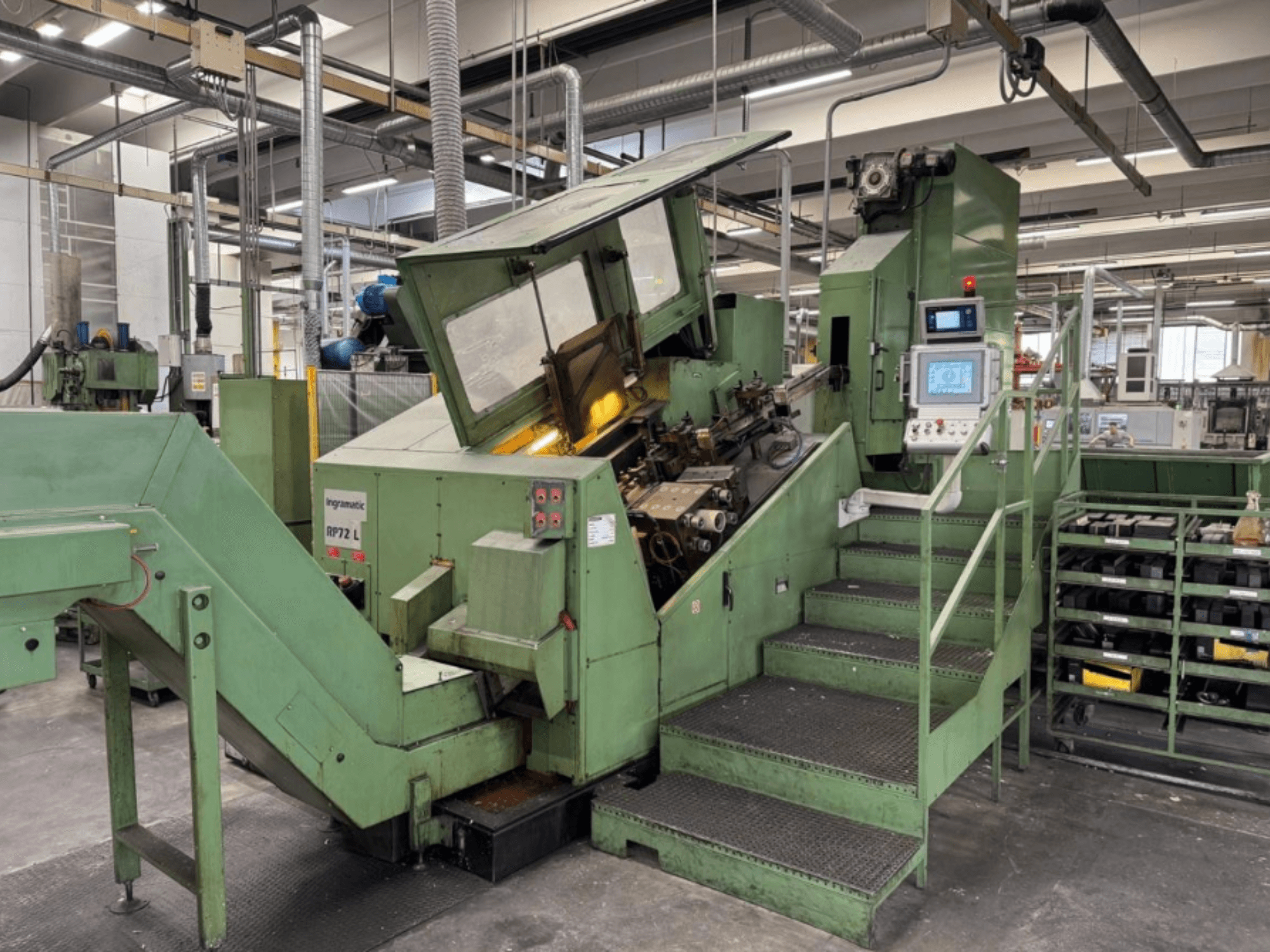Ingramatic RP72 L, yeşil renkli endüstriyel makine, önden görünüm; bir kontrol paneli ve metal ızgara platformlu basamaklara sahiptir.