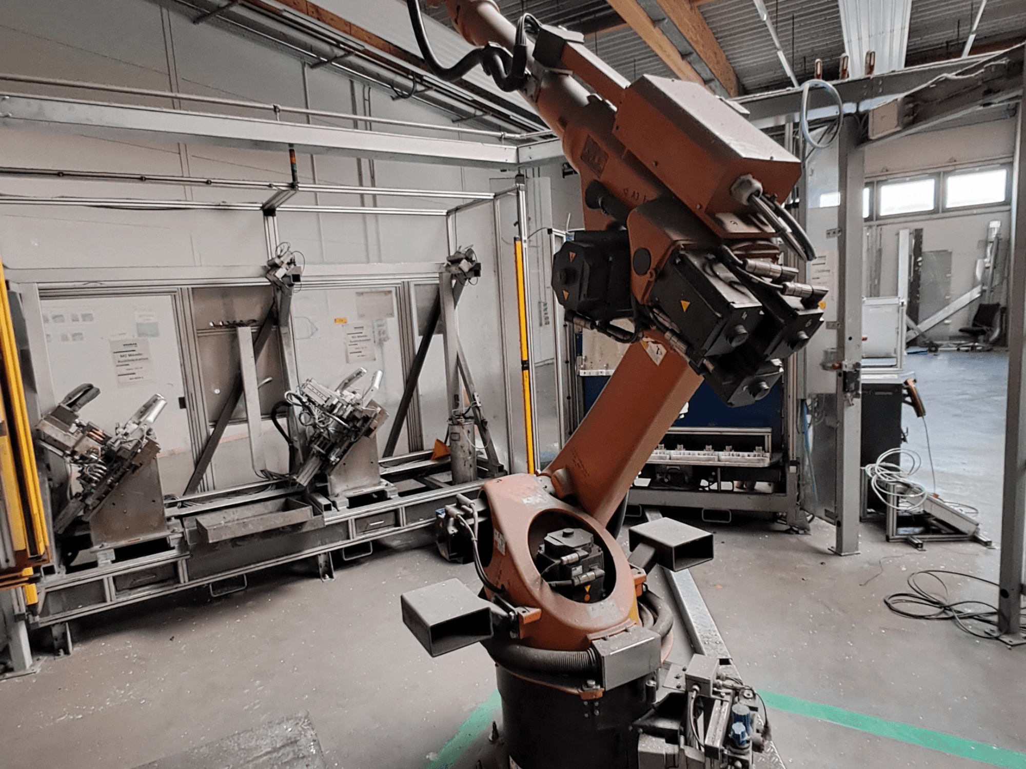 Endüstriyel bir ortamda bulunan KUKA KR 30L16-2 robot kolu, yandan görünüm; kolun eklemleri ve kavrama aletleri gösterilmektedir.