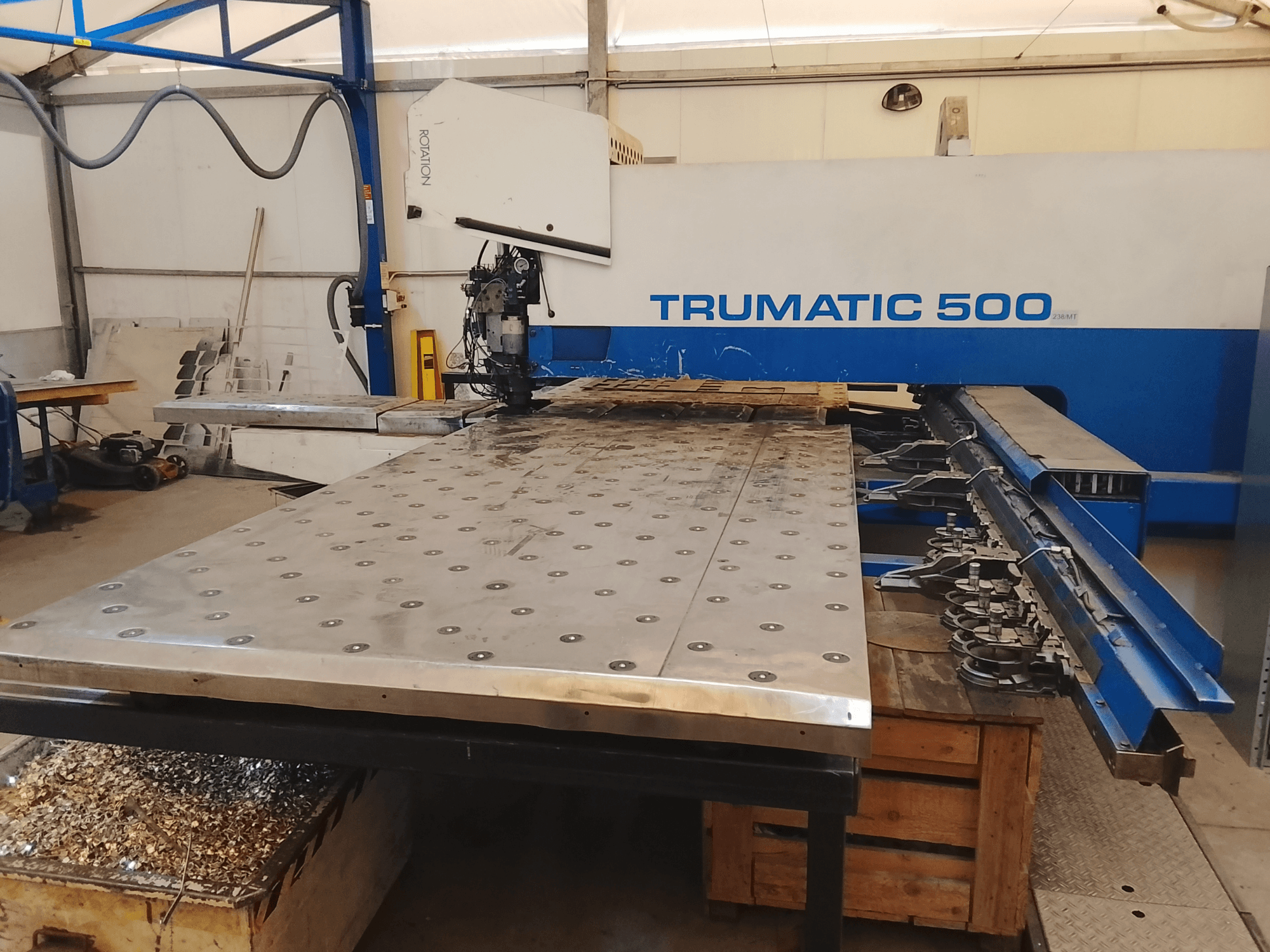 Trumatic 500 CNC makinesi, üstten görünüm, altında monte edilmiş aletler ve talaşlar bulunan büyük bir metal kesme tablası.