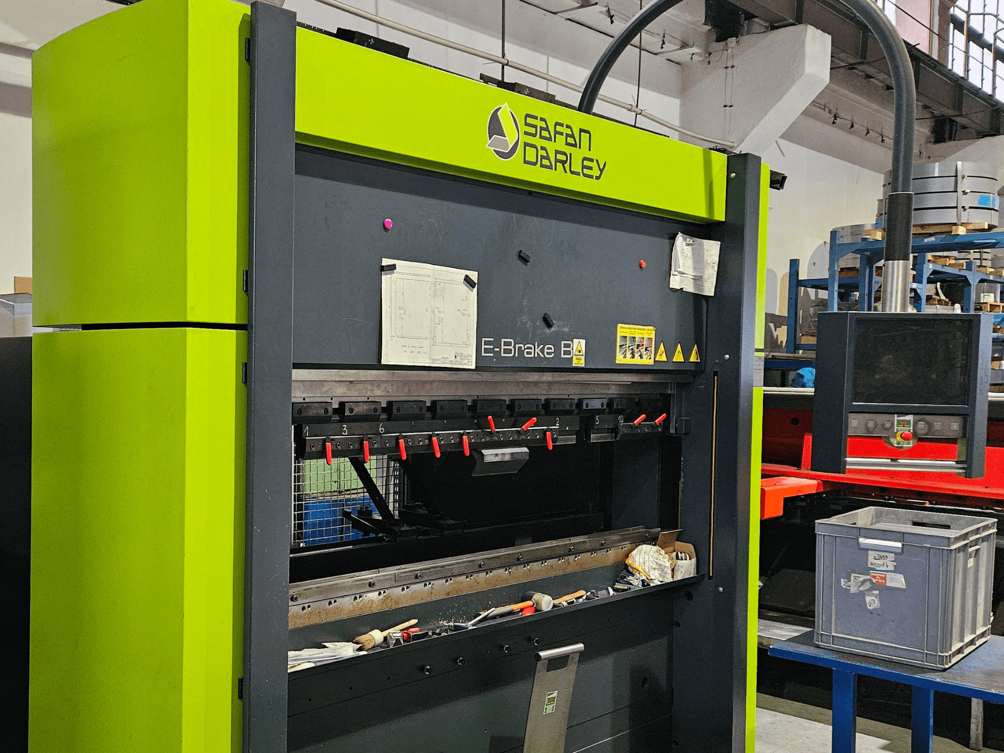 Bir atölyede bulunan SAFAN E-Brake B 50-2050 pres fren makinesi; önden bakıldığında kırmızı sıkıştırma aletleri ve kontrol paneli görülüyor.