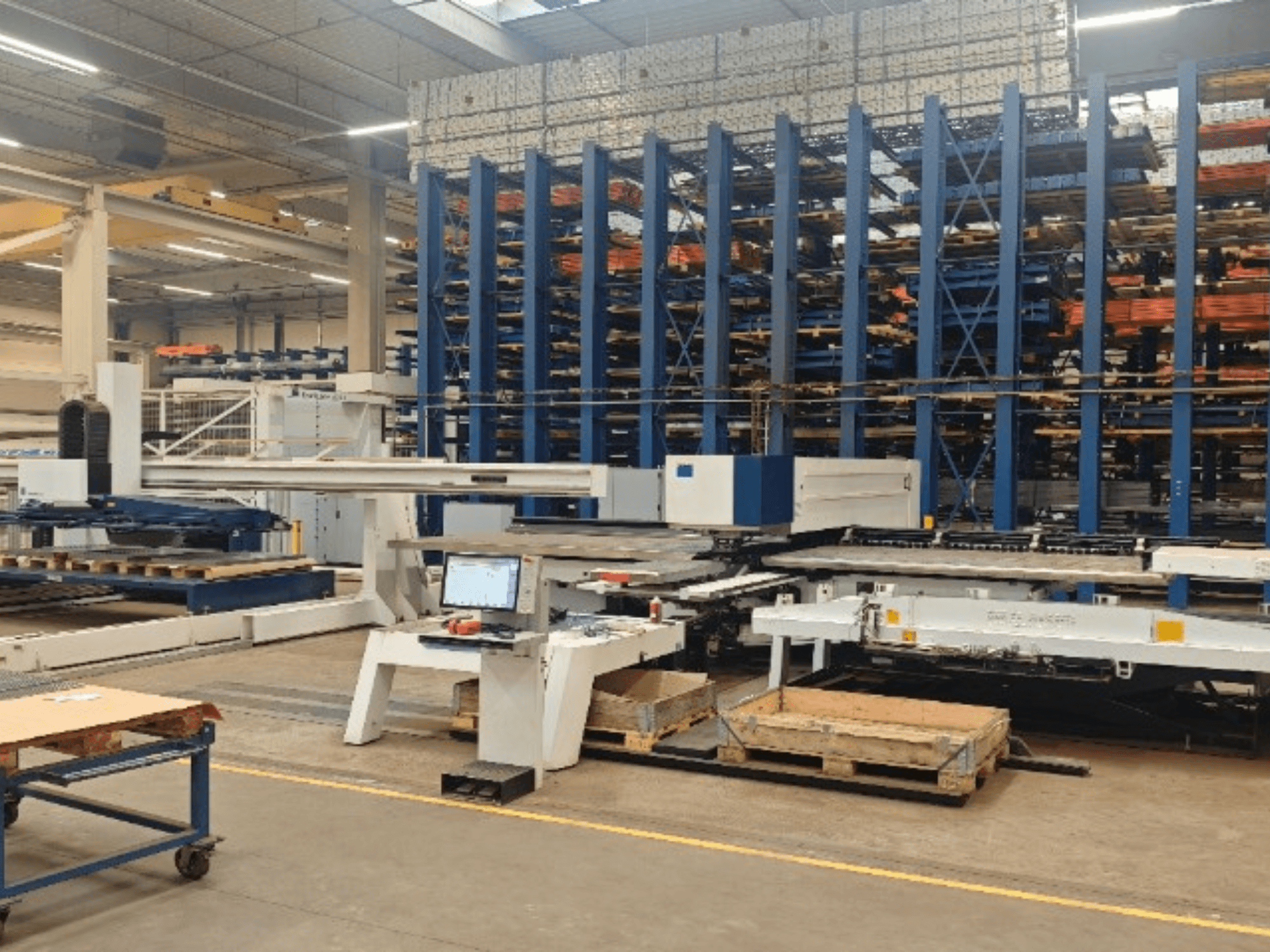 Bir atölyede bulunan TRUMPF TruPunch 5000 S12 CNC delme makinesi; kontrol paneli ve depolama alanı ile birlikte önden görünüm.