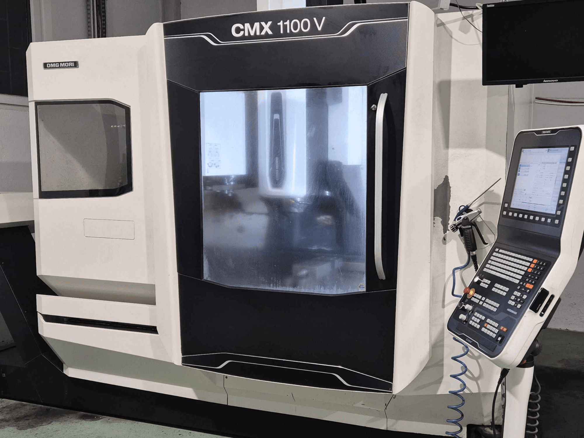 DMG Mori CMX 1100 V, kontrol paneli, dijital ekran ve soğutma sıvısı kurulumu görünen CNC makinesinin önden görünümü.