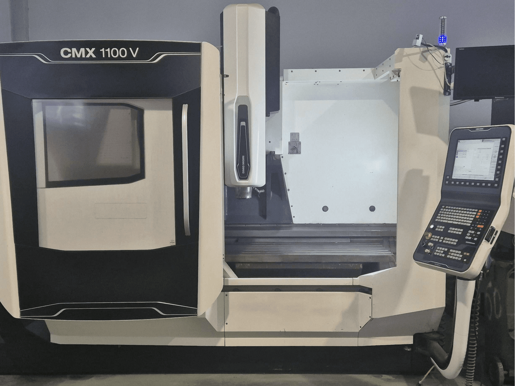 DMG MORI CMX 1100 V dikey işleme merkezi; kontrol paneli ve makine yatağını gösteren önden görünüm.