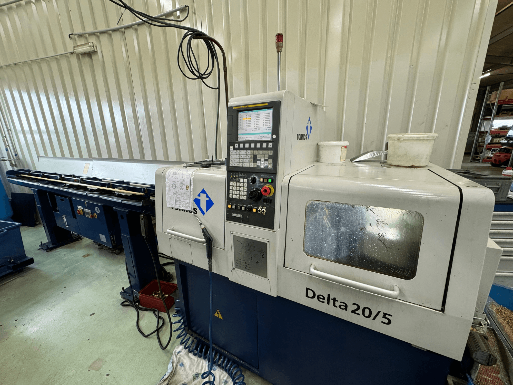 Torino Delta 20/5 CNC makinesi, önden görünüm, kontrol paneli ve çalışma alanı ile. Kazınmış cam ve görünür kablo tesisatı.