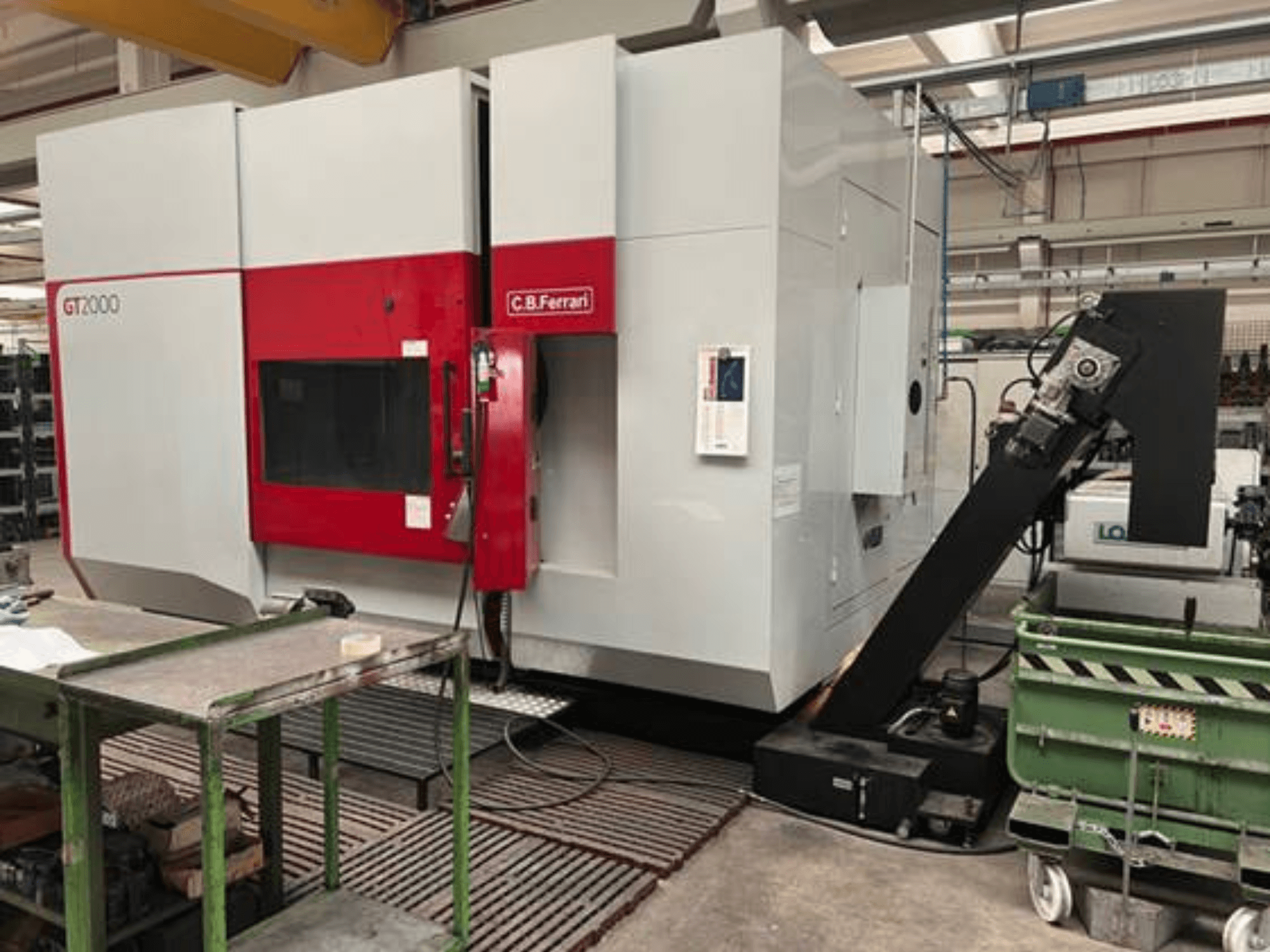 C.B. Ferrari GT2000 freze makinesinin önden görünümü, robotik kol ve yeşil arabalı endüstriyel çalışma alanı.