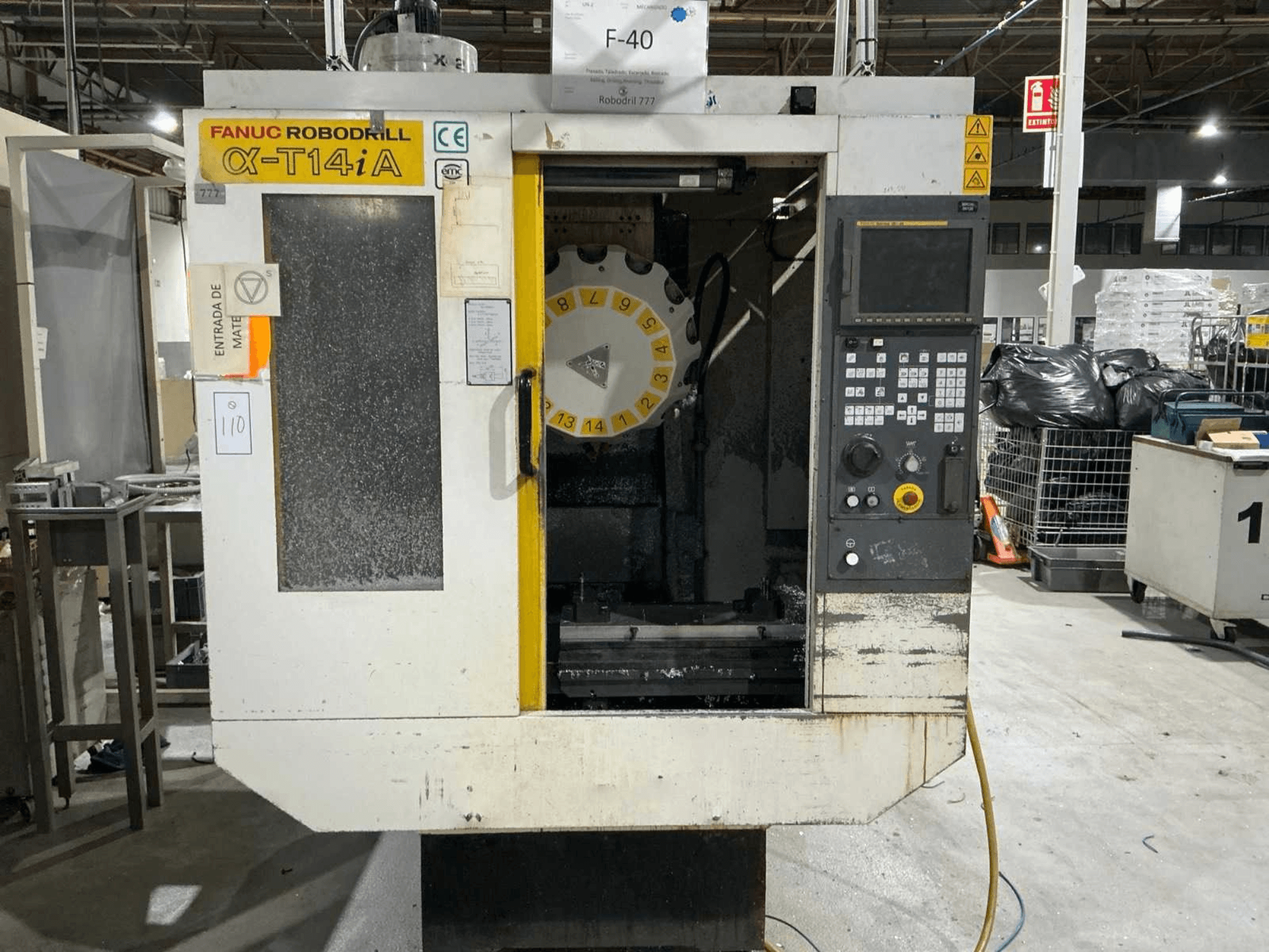 FANUC ROBODRILL α-T14iB dikey işleme merkezi, kontrol paneli ve takım karuselini gösteren önden görünüm.