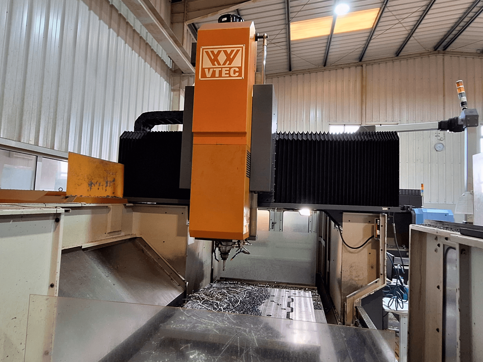 PORTIC'in VTEC model portal freze makinesi, kesici takım ve metal talaşı görünür şekilde önden gösterilmiştir.