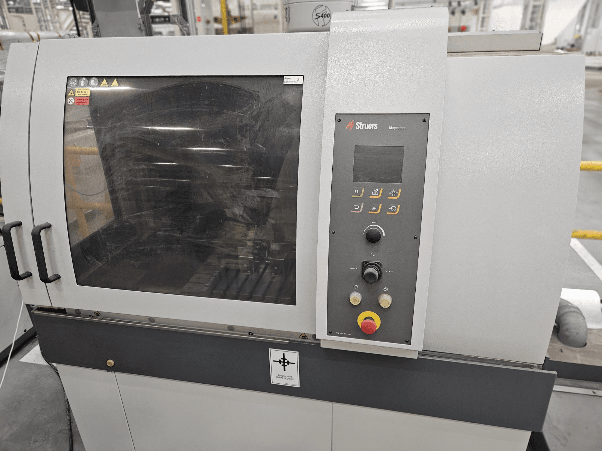 Struers Magpentor makinesinin kontrol paneli, düğmeleri ve geniş görüntüleme penceresi ile önden görünümü. Teknik etiketler görülebilir.