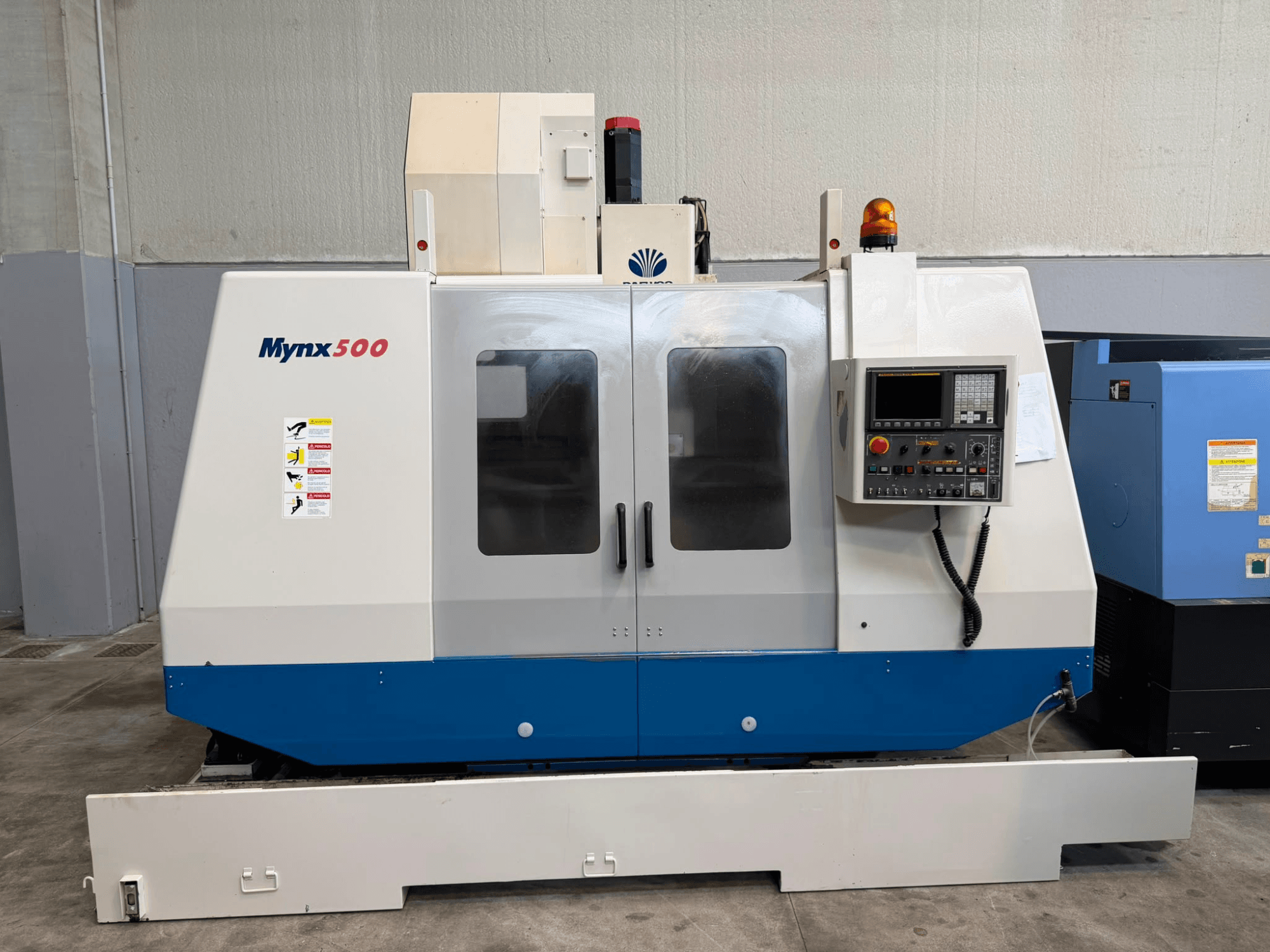Kontrol paneli, güvenlik ışıkları ve şeffaf erişim kapakları bulunan DAEWOO MYNX 500 dikey işleme merkezinin önden görünümü.
