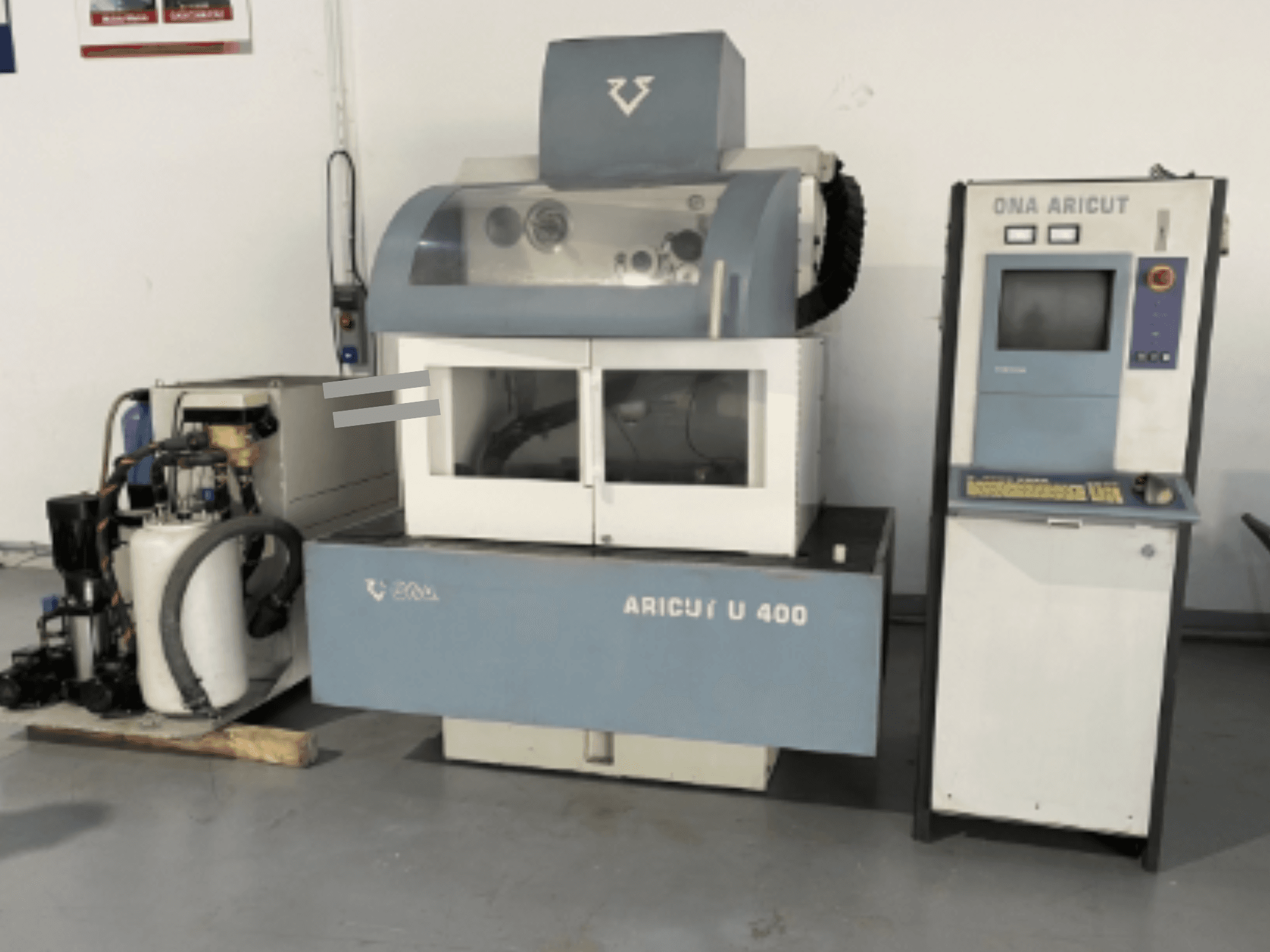 ONA U 400 Tel Erozyon Makinesi önden bakıldığında, yan tarafta bir kontrol konsolu ve soğutma sıvısı ünitesi bulunur.