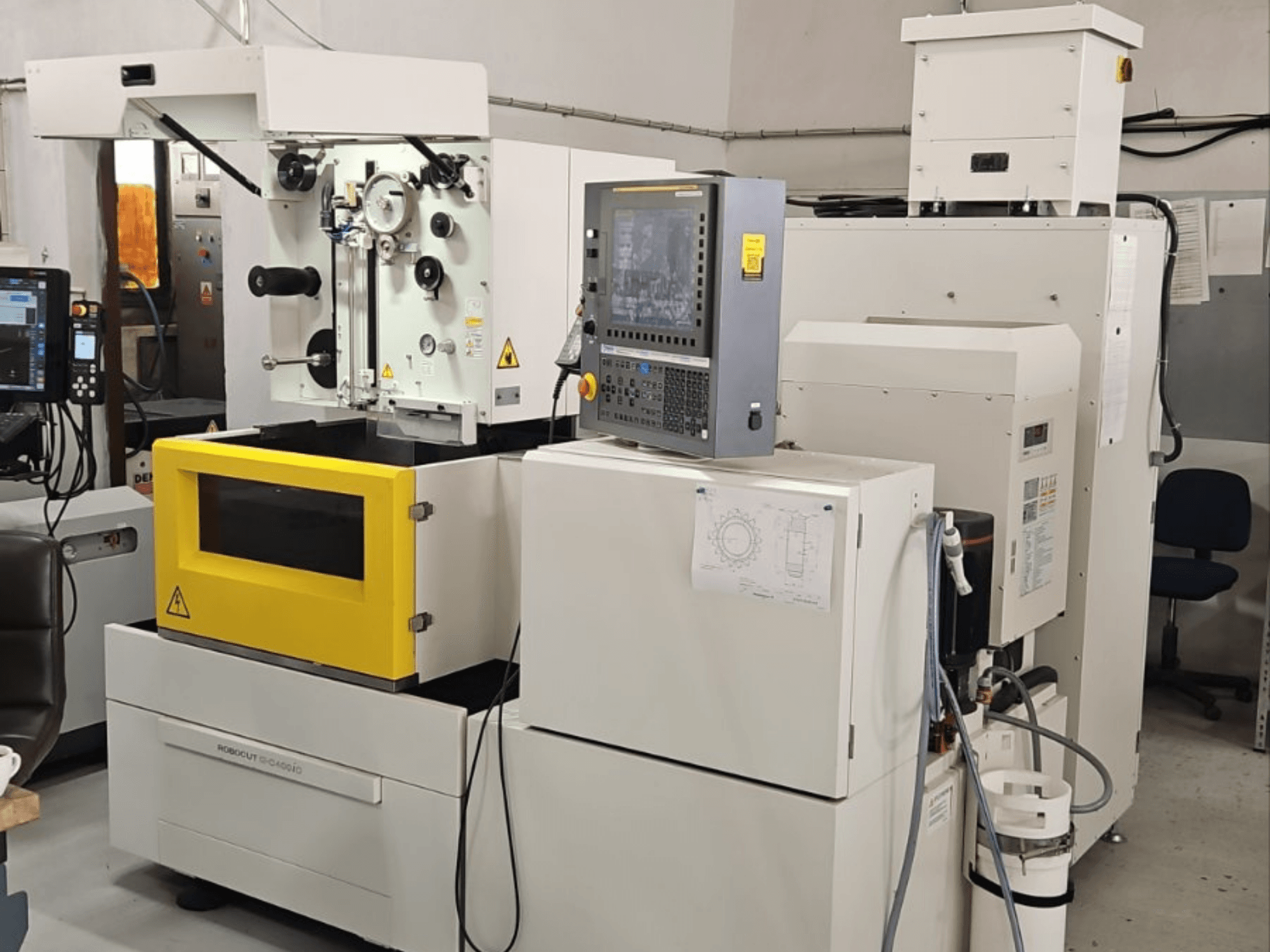 FANUC Robocut alpha C400iC Tel EDM makinesi; kontrol paneli ve sarı renkli işleme odasını gösteren önden görünüm.