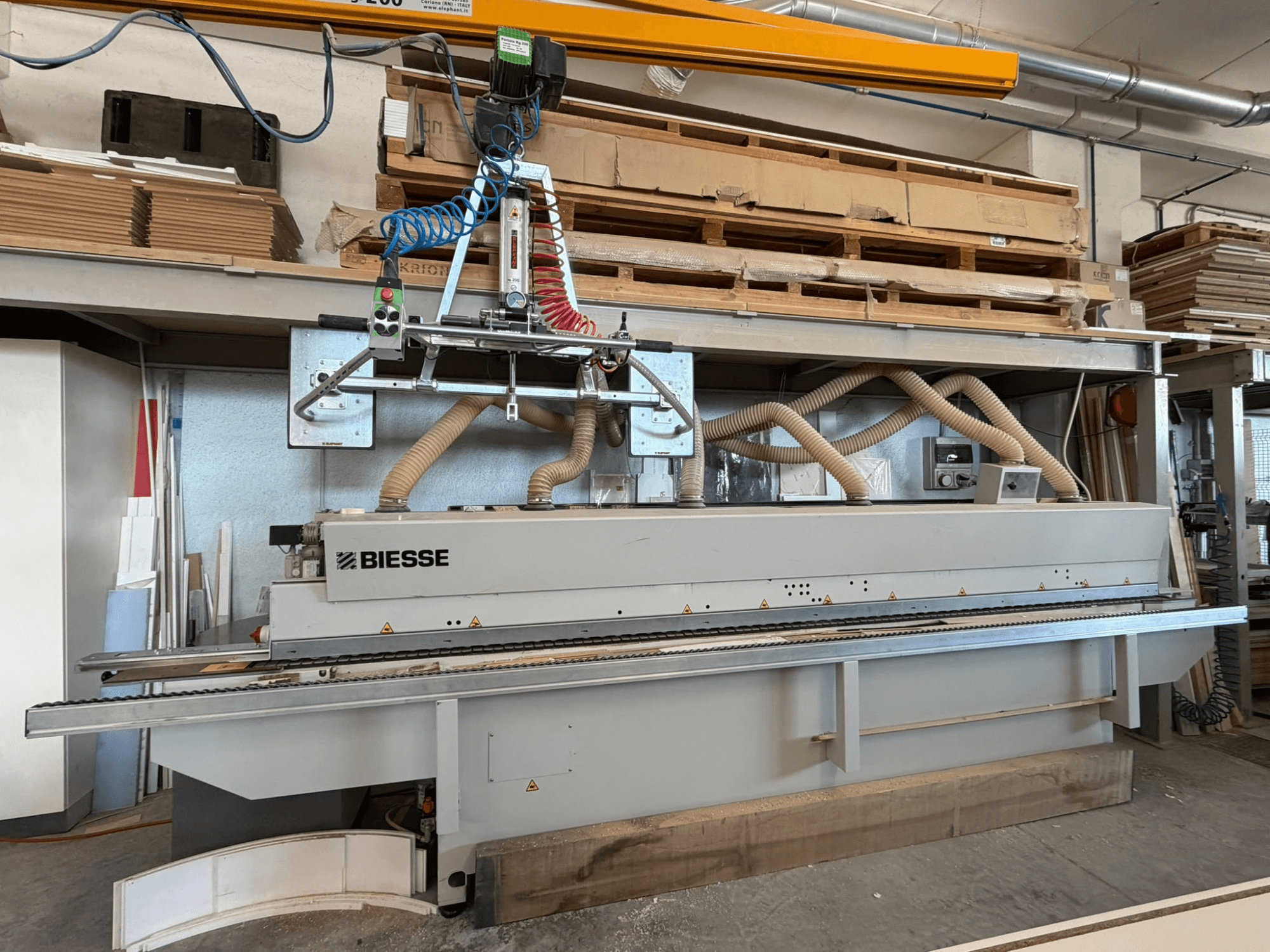Bir atölyede bulunan BIESSE AKRON 1330 kenar kaplama makinesinin, kontrol paneli ve toz emme sistemi ile birlikte önden görünüşü.