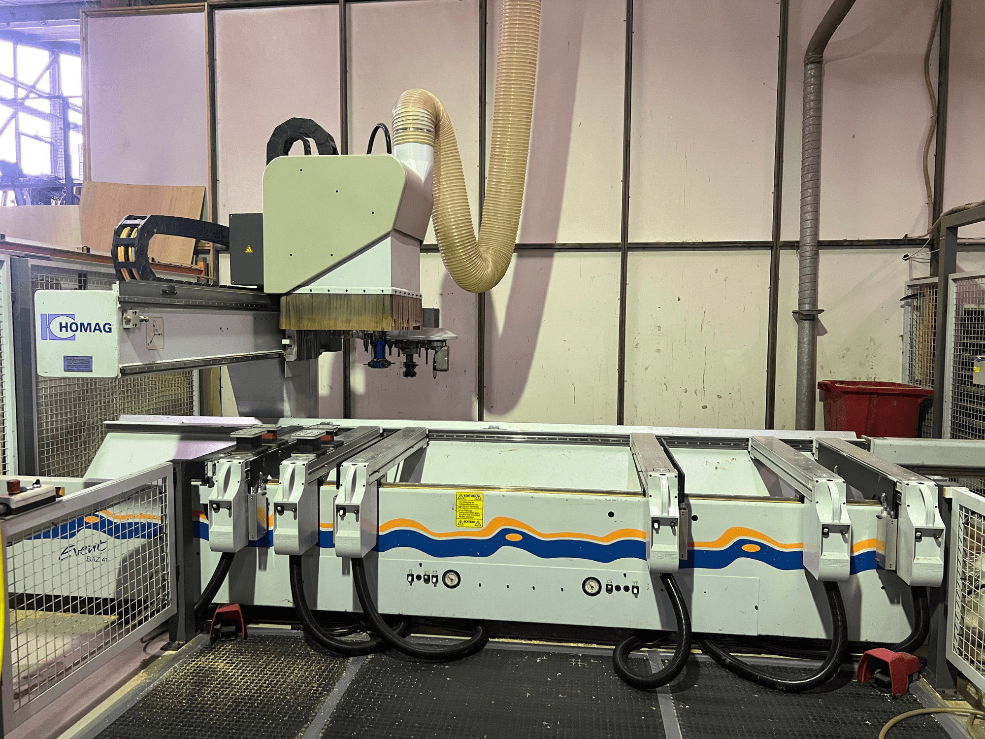 Atölyede HOMAG BIZ 4 CNC makinesi; toz emme sistemini ve kabloların bulunduğu kontrol panelini gösteren önden görünüm.