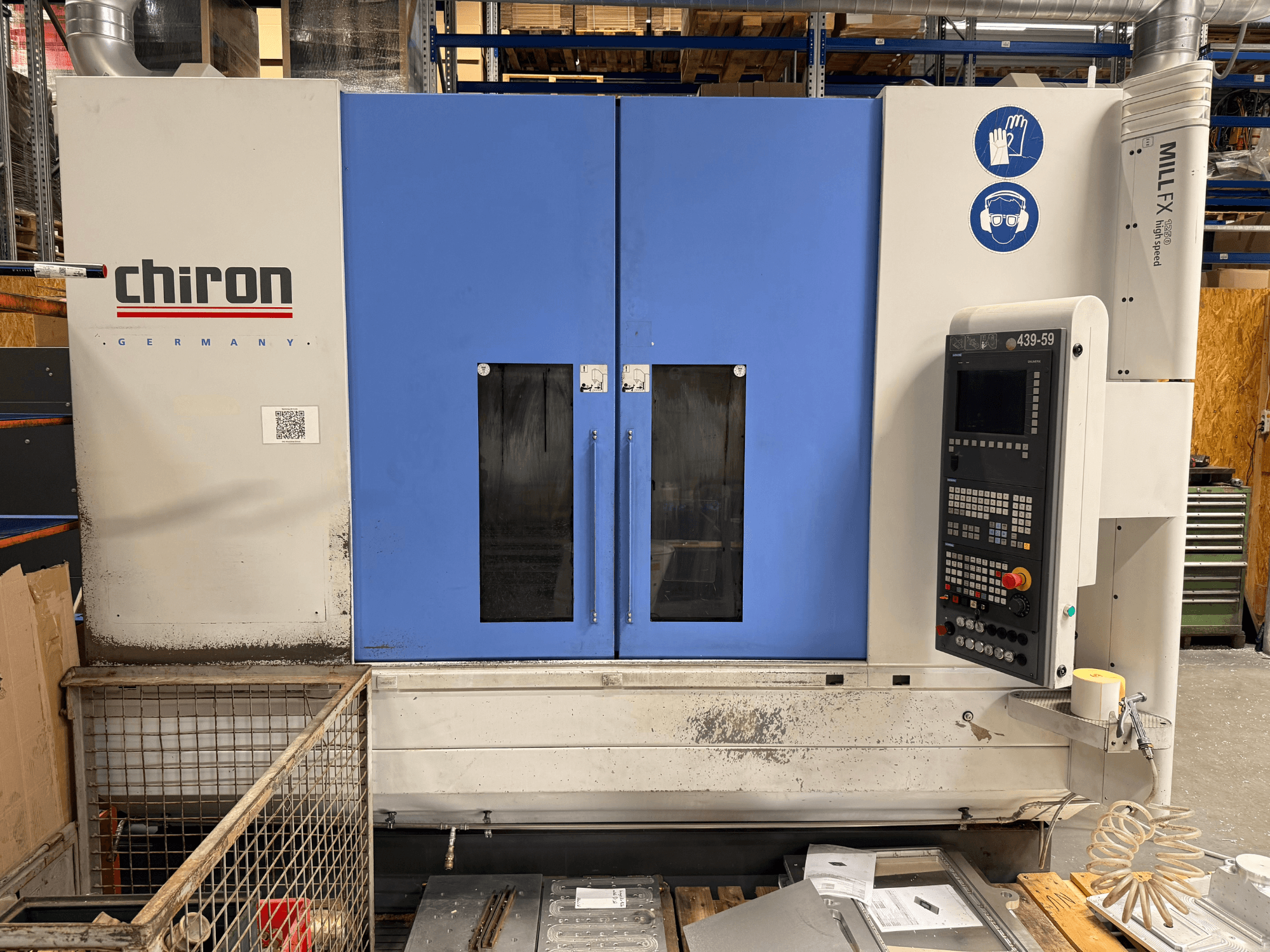 CHIRON MILL FX 1250 dikey işleme merkezi, önden görünüm; kontrol paneli ve güvenlik sembolleriyle birlikte, hassas işlere hazır.