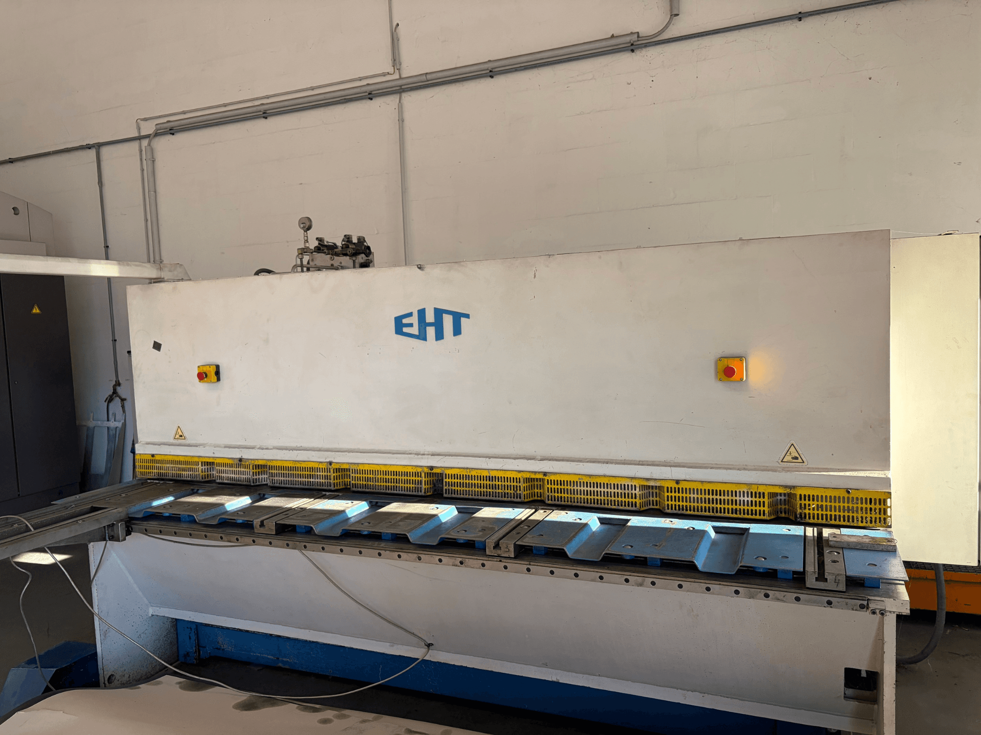 Bir atölyede bulunan EHT ISS 5-30 hidrolik kesme makinesi; kontrol paneli ve kesme yüzeyini gösteren önden görünüm.