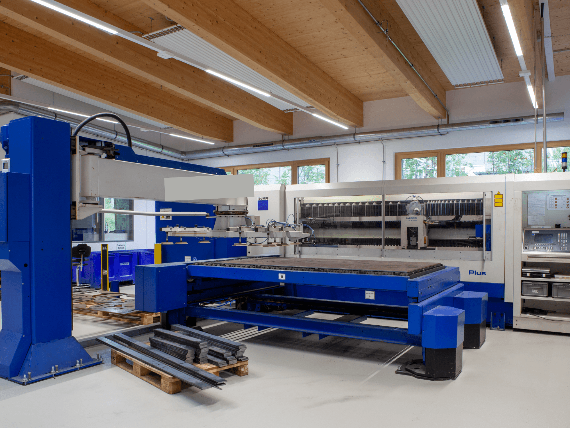 Bir atölyede bulunan TRUMPF TRUMATIC L 2530 Plus CO₂ lazer kesim makinesi, geniş kesim tablası ve endüstriyel tasarımıyla dikkat çekiyor.